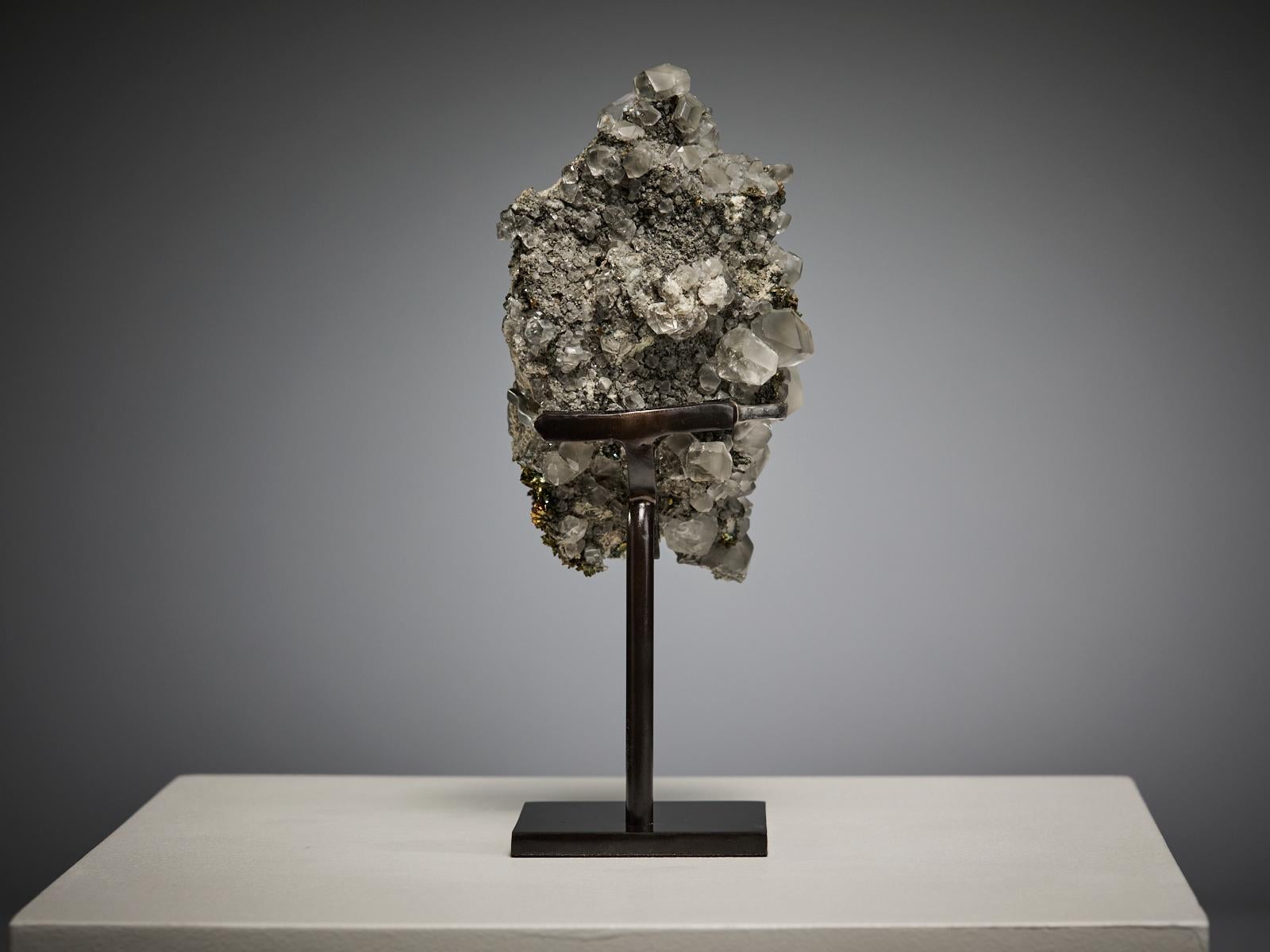 This striking specimen from the Linwood Mine, Buffalo, Scott County, Iowa, showcases beautifully formed transparent calcite crystals of varying sizes rising gracefully from their natural matrix, accompanied by clusters of iridescent marcasite. The