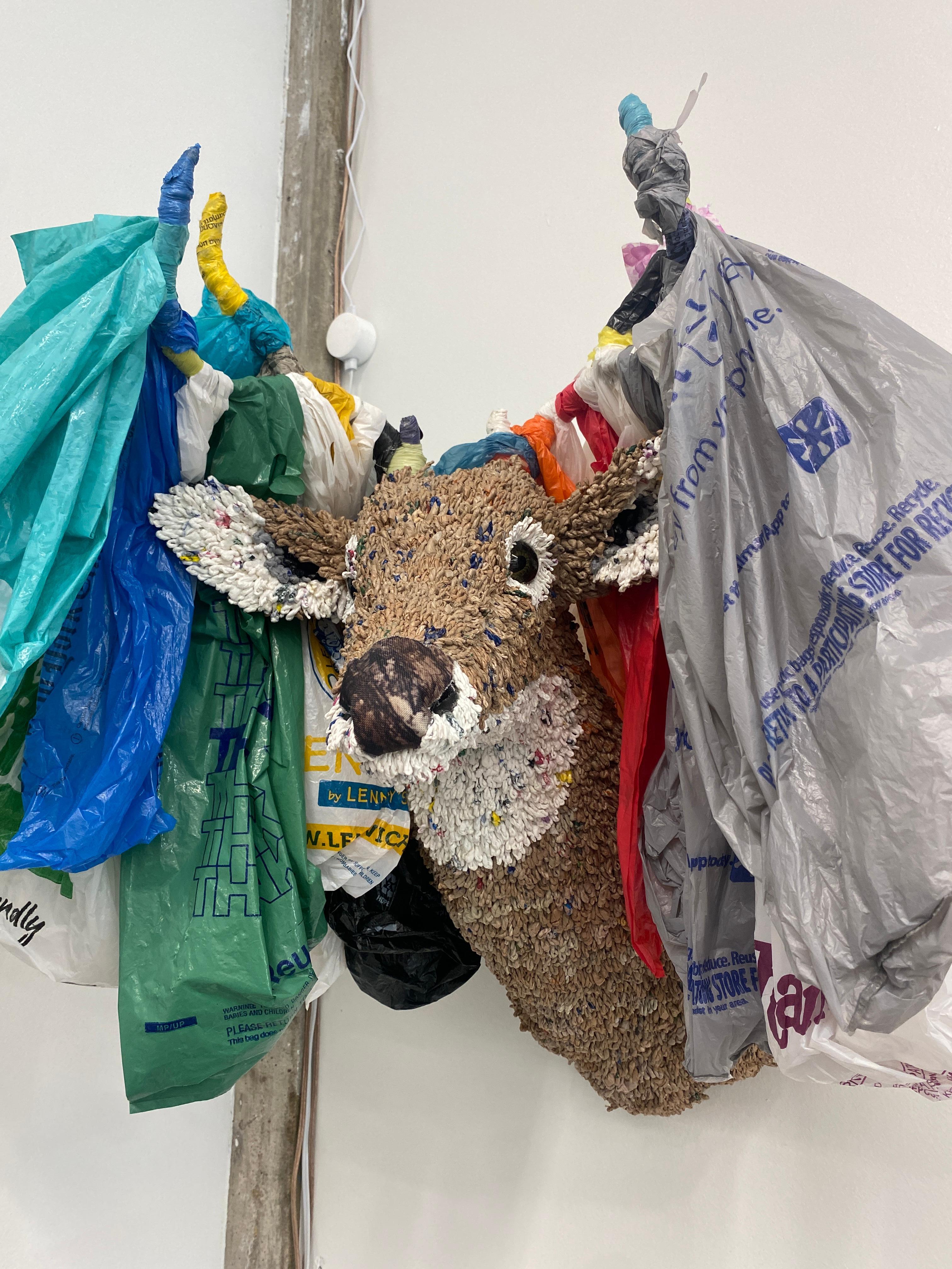 Escultura de Calder Kamin de 2018, hecha con materiales reciclados, como bolsas de plástico, koozies, tapones, cubiertos, huevos de plástico, envases de plástico, tapones de botellas, tapones de rotuladores, piezas de juegos, correo basura y madera.