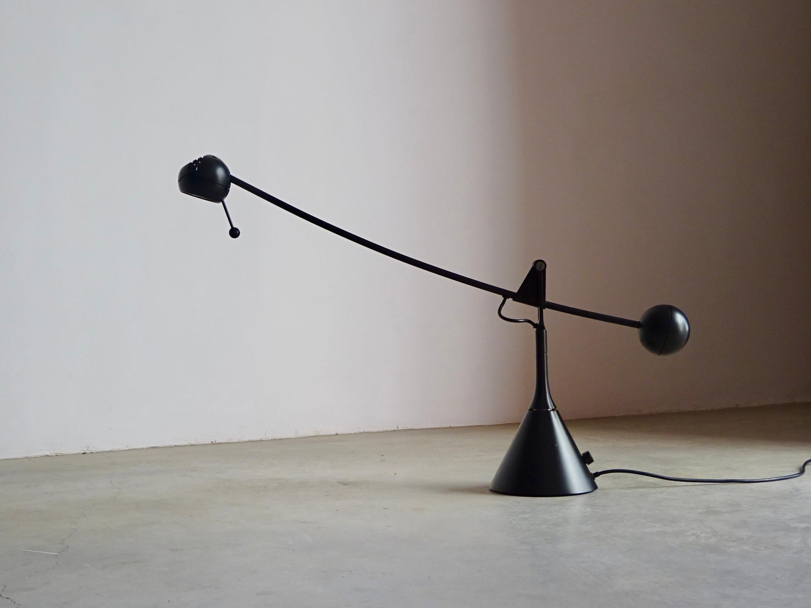 “Calder” table lamp by Enric Franch for Metalarte, 1974.

Metallic mobile lamp with halogen light for desk with dimmer switch control and transformer on the base. Finish: black satin lacquered.

High 40cm / Overall arm light 92.5cm

Halogen  H3 12v.