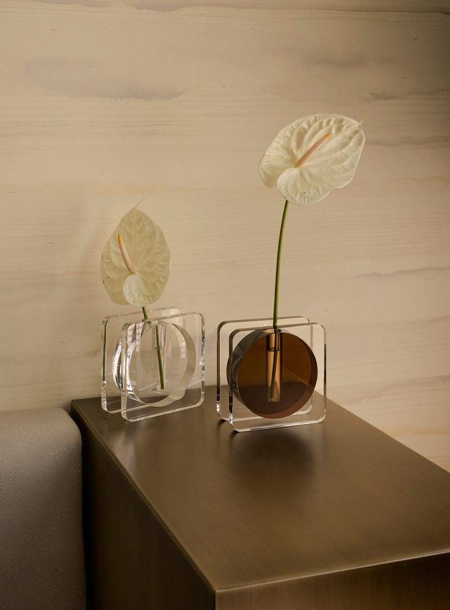 Un'esplorazione moderna della luce e della forma, il vaso di cristallo Caldera si ispira alla Tomba di Brion di Carlo Scarpa. In cristallo trasparente o con il centro in caldo color ambra, questo vaso a stelo è sia un recipiente funzionale che un