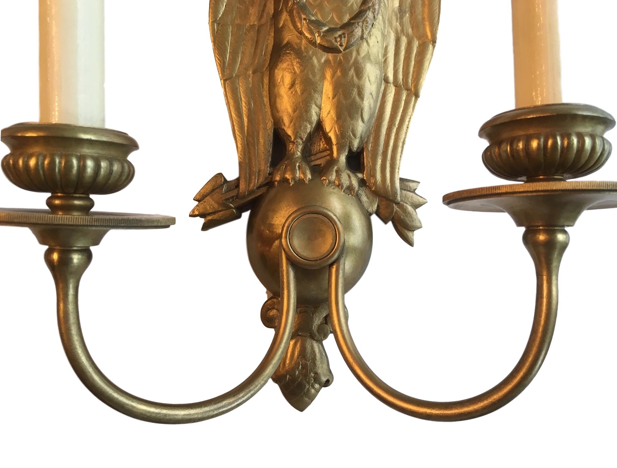 Pair of 1920s American Caldwell gilt bronze double light sconces with eagle shaped backplate.

Measurements:
Height 12'
Width 10.5?
Depth 5?
