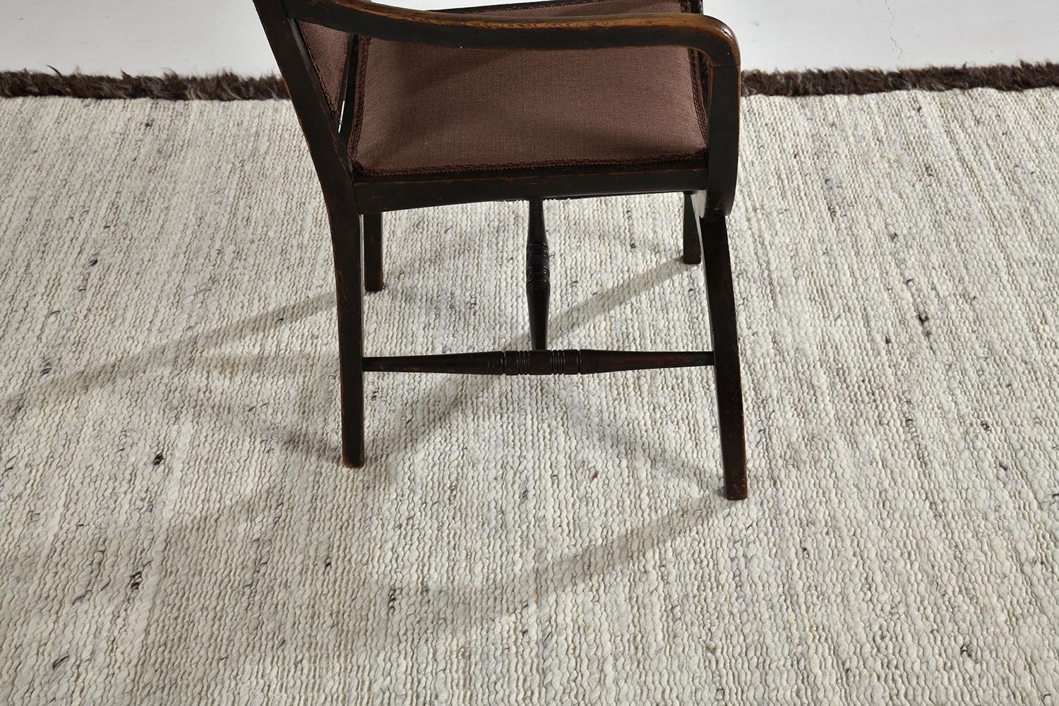 'Caleta' is a beautiful handwoven speckled ivory flat weave, bordered with rich brown shag. A simple yet interesting design, 'Caleta' is a luxurious and timely design that will elevate any space. Mehraban's Sabbia collection is unique for its play