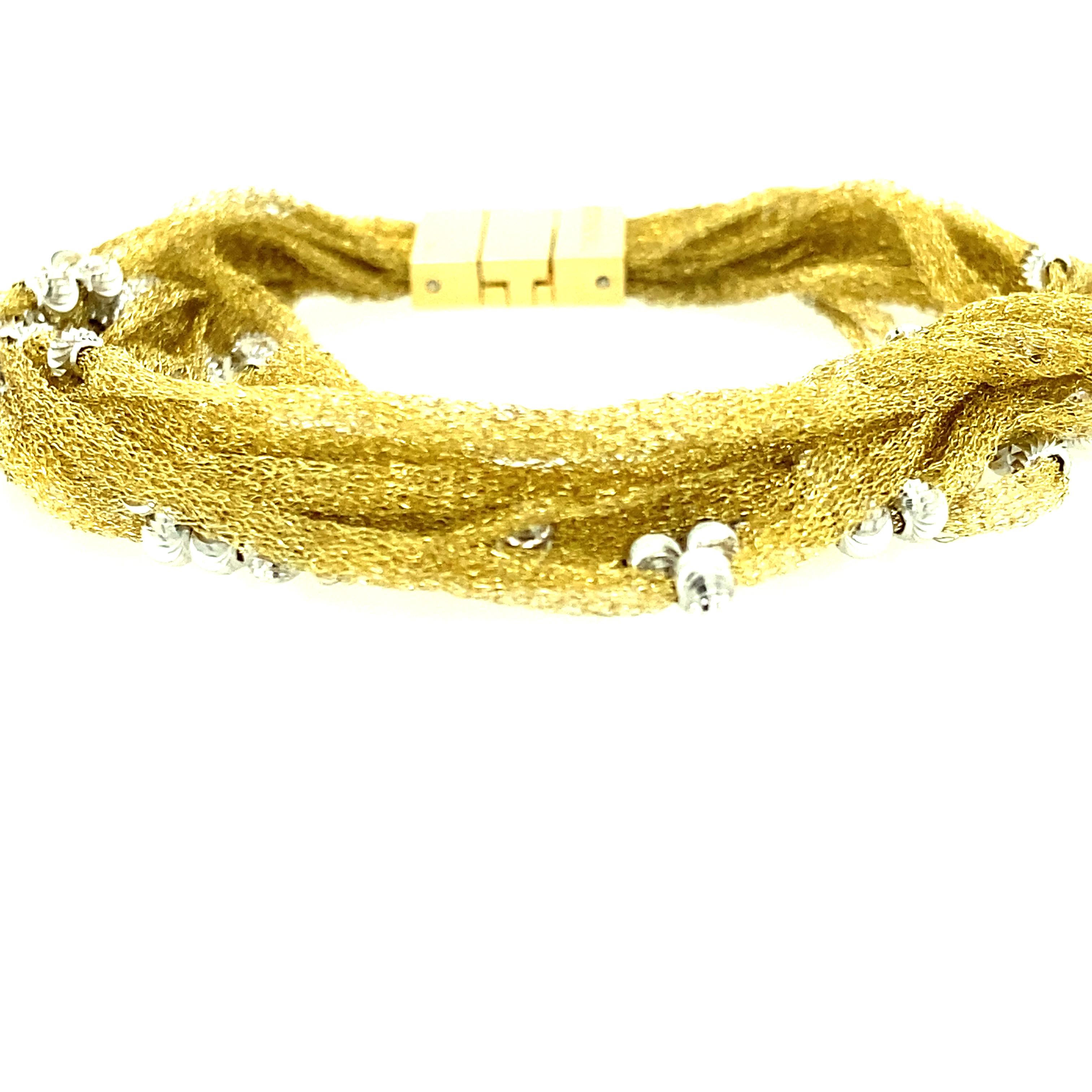 One 18 karat yellow gold (stamped 750 ITALY) multi strand mesh bracelet by Calgaro set with sterling silver beads.  The bracelet measures 7 inches long and is complete with a hidden closure clasp.