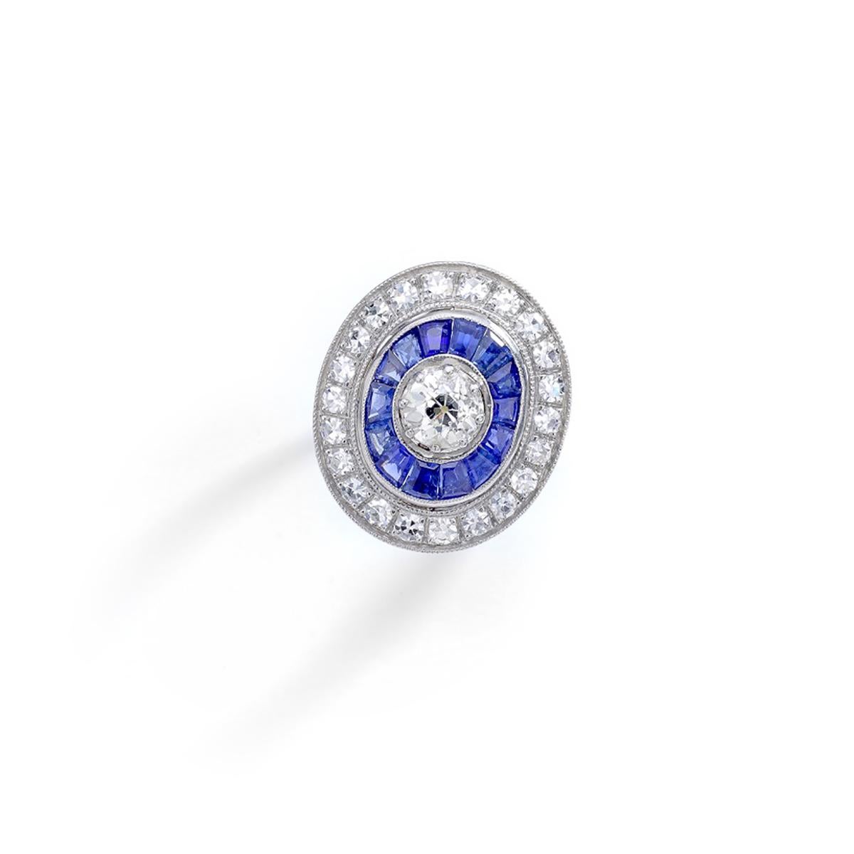 Superb Platinum ring centered by an Old-mine cut diamond surrounded by calibrated sapphire and diamond.
The side border is beautifully engraved of flowers and Art Deco motifs.

Total diamond weight: 1.40 carats.
Gross weight: 8.12 grams.
