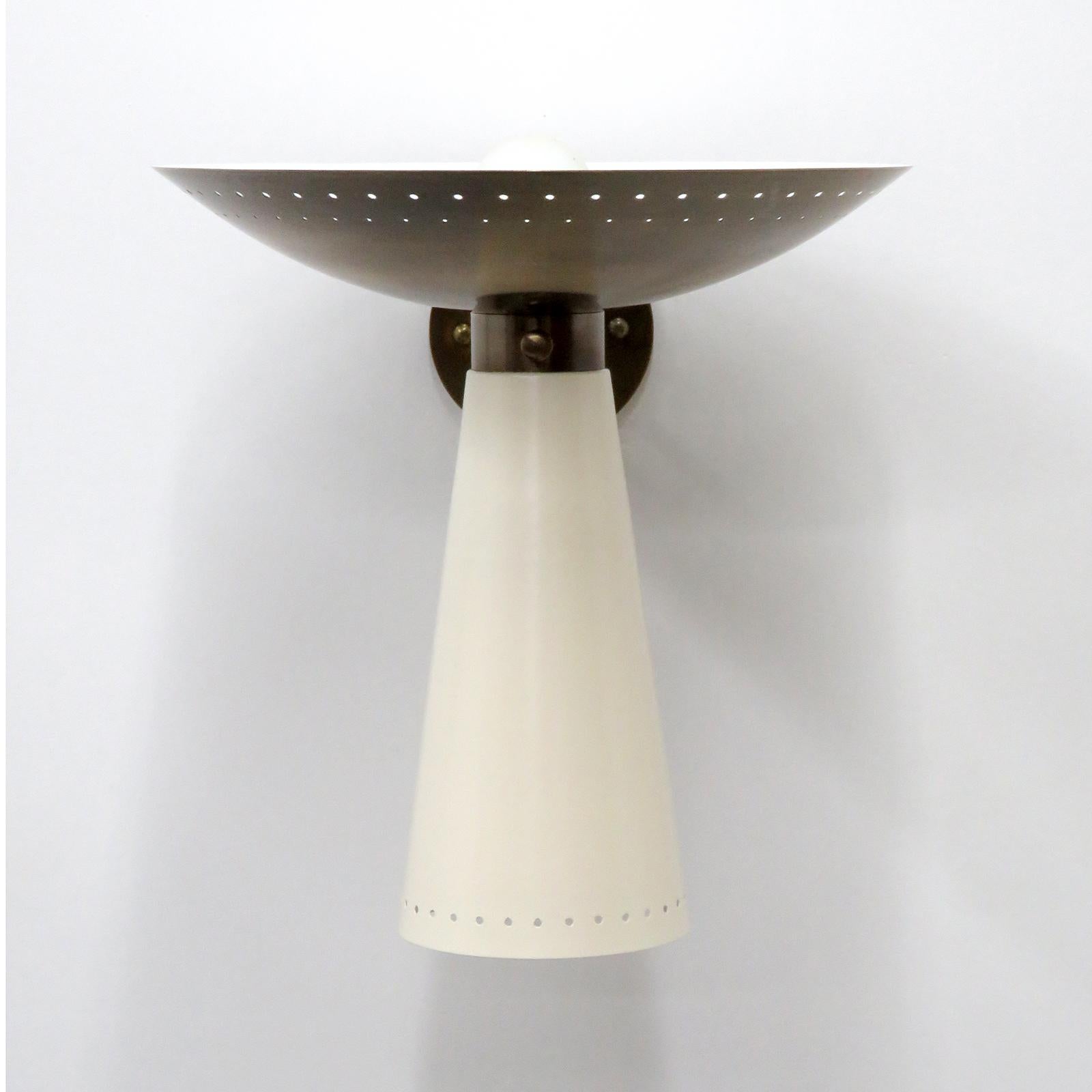 Elegant articulate Calice wall lights designed by Gallery L7, handcrafted and finished in Los Angeles from American brass, with an aged brass up-light and a egg shell white enameled down-light. Perforations along the rims and on/off switch on the