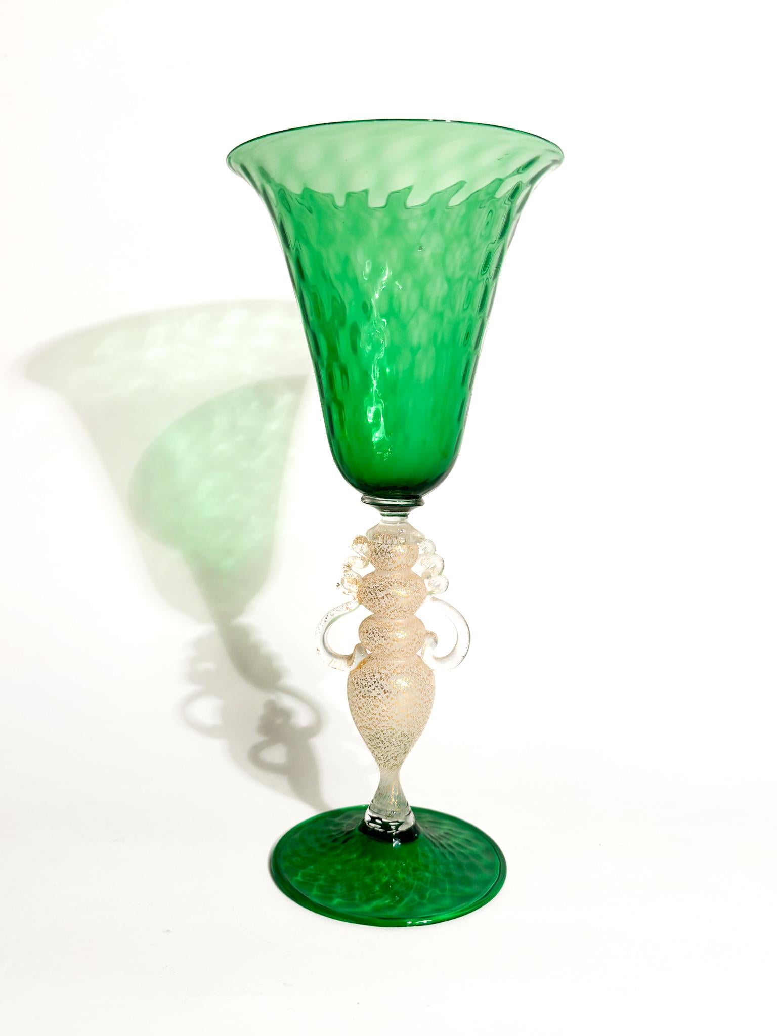 Verre de Murano vert soufflé à la main et feuille d'or, fabriqué dans les années 1970

Ø cm 10,5 h cm 24

Le verre de Murano est un type de verre d'art produit sur l'île de Murano, près de Venise, en Italie. Il est connu pour sa beauté, sa qualité