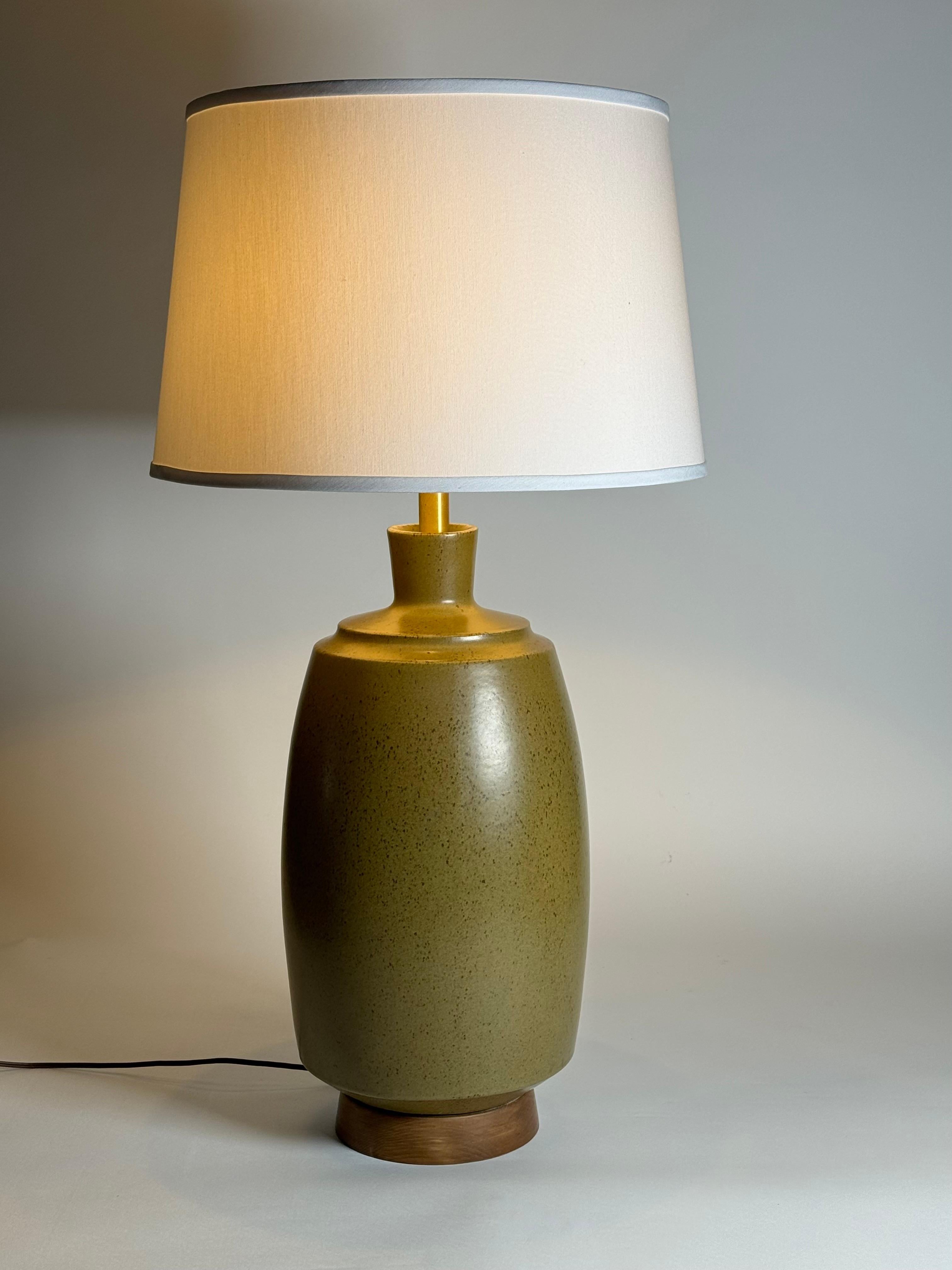 Ceramic table lamp by California ceramic artist David Cressey having a brown speckled glaze over an earth toned green under glaze. A tapered form with a step wedge top going into rounded cylinder body and ending in an angled in bottom resting on a