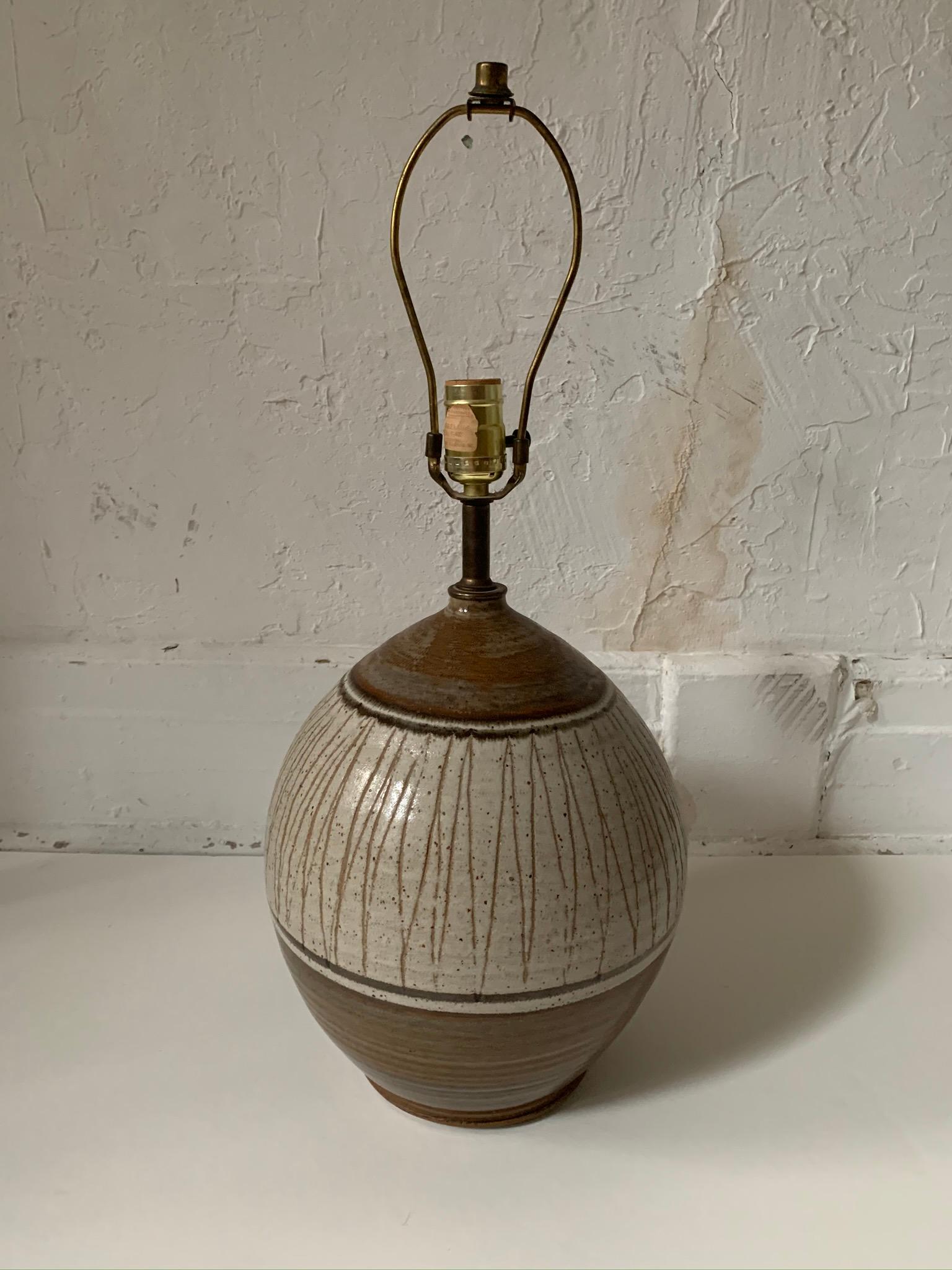 Vintage pottery table lamp by California Ceramic Designers, USA, circa 1950.

Features an incised pattern in a range of earthtones.

Signed with sticker to socket.

Felt base.

Dimensions:
23 inches H to top of finial
14.5 inches H to