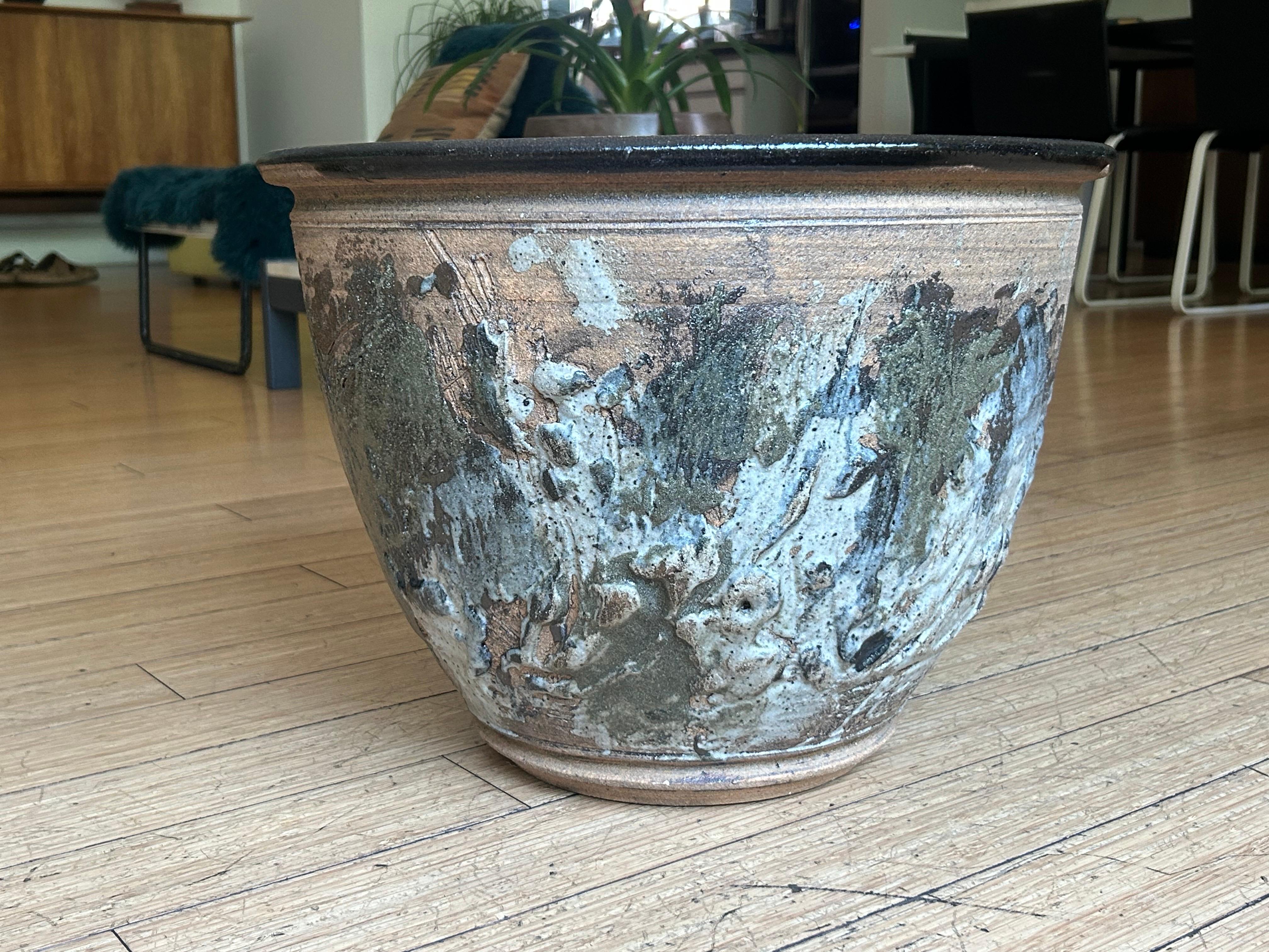 One-of-a-kind.
Wheel thrown natural stoneware planter.
Hand applied abstract expressionist textured glaze on the outside with black glaze inside.
No chips, cracks or repairs.
No drain holes. Great for indoors. 
Presents well for decor with a nice