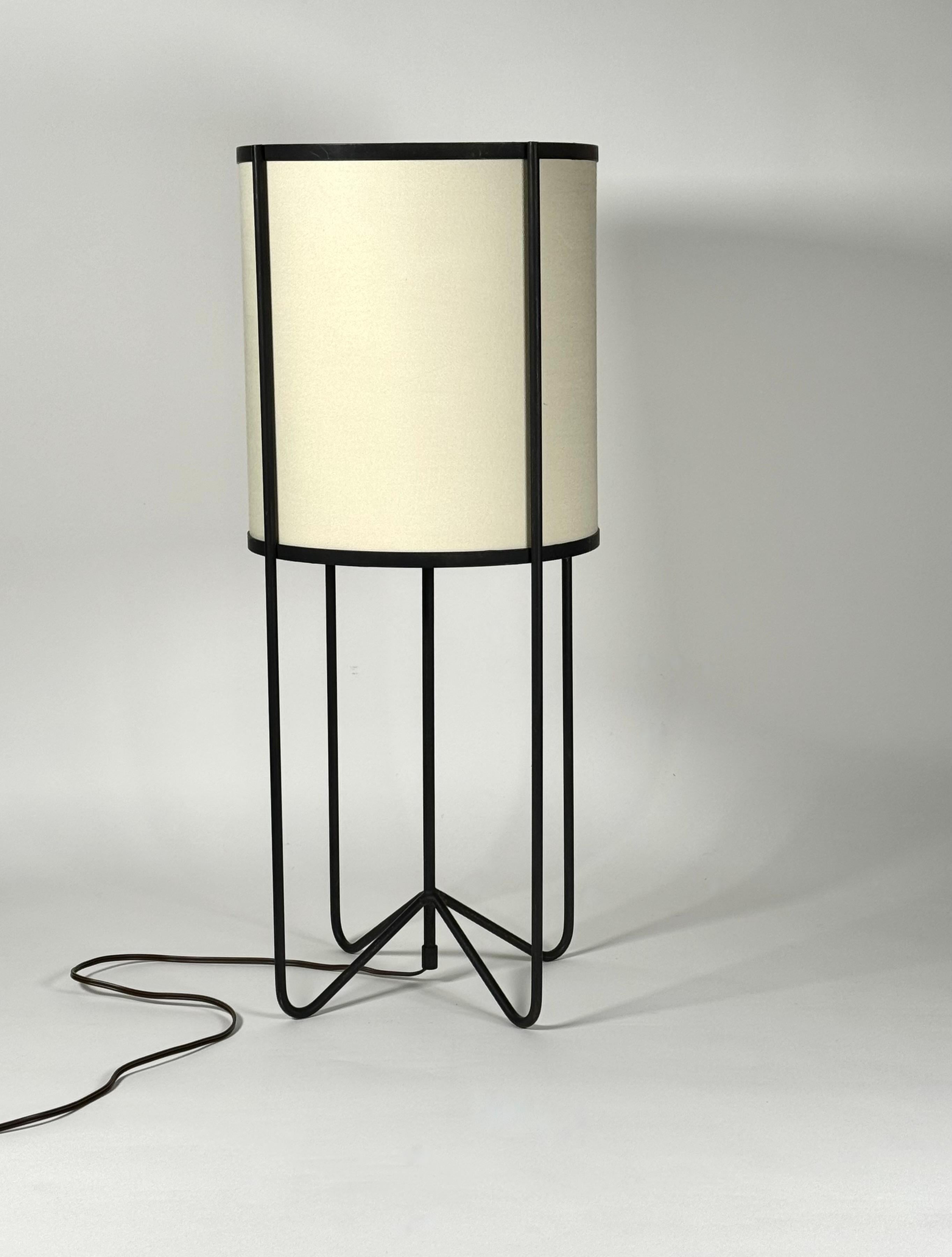 Wrought iron and linen table lamp which embodies the design ethos of the 1950s California Design Lifestyle viewpoint, this design with curved leges and drum shade evokes the connection with the Pacific Rim influence of Japanese culture in Modernist