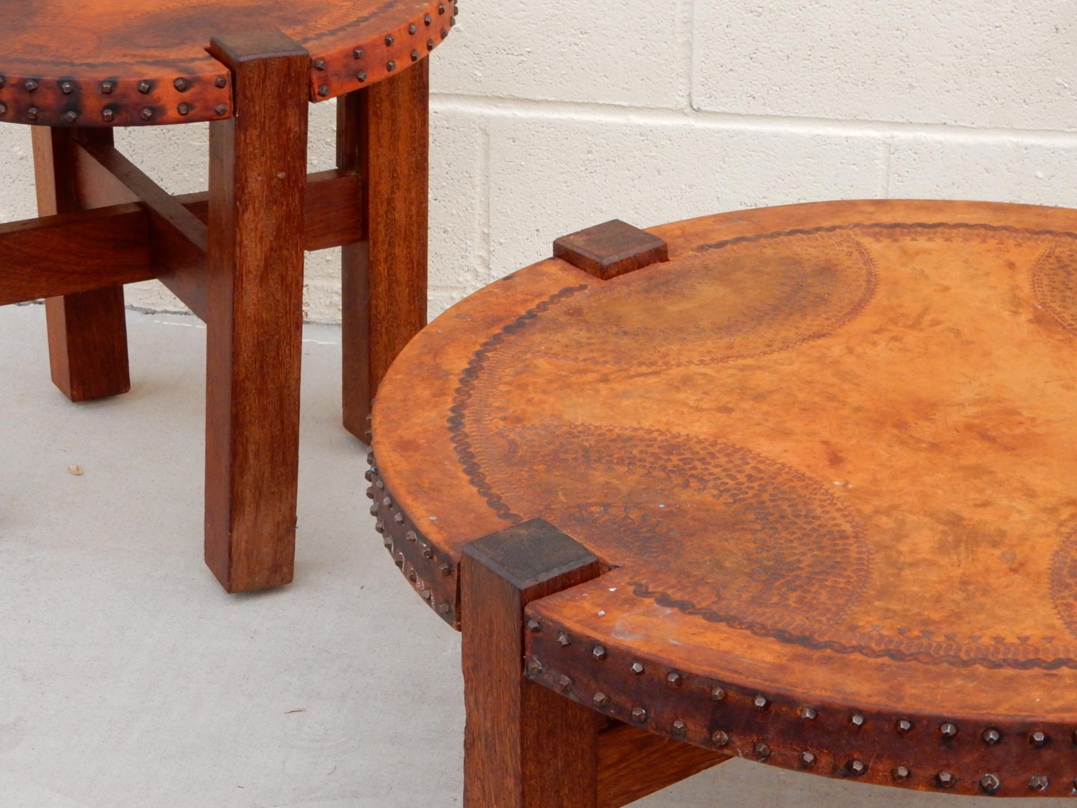 1940s Mission era tooled leather wrapped top table set with hand forged nail edge.
Gorgeous aged patina on leather. Classic Santa Barbara patio design/style.
Sold as a set.

Both disassemble with ease into 3 parts.
Size:
large is 32 W x 14 T,