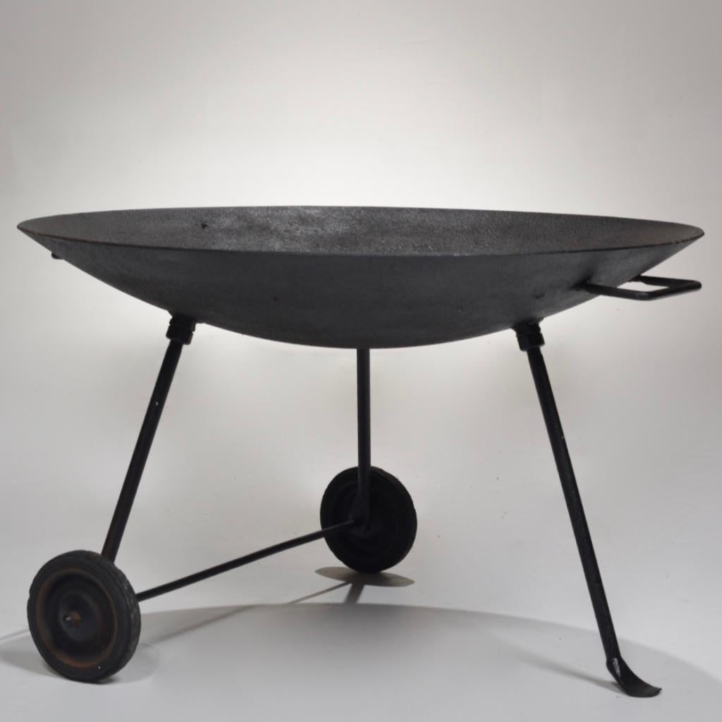 This rare Stan Hawk iron fire pit was officially approved to be in the case-study houses. It features an exceptionally functional and streamlined design - a wide brimmed iron bowl with a handle and two wheels for easy transportation, along with a