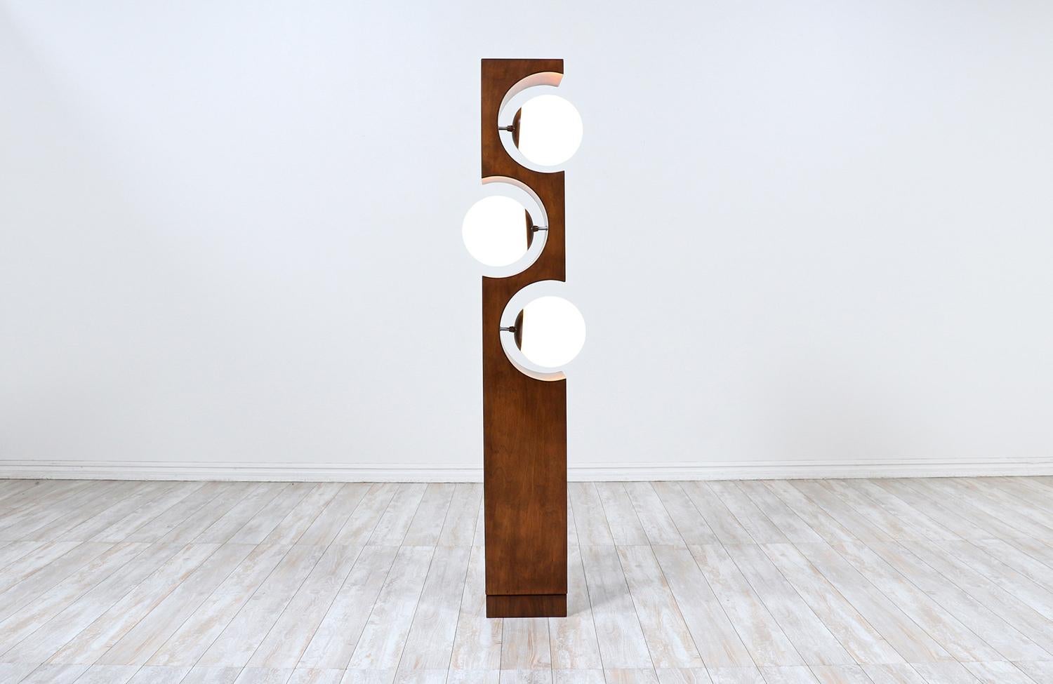 Mid-Century floor lamp designed and manufactured by Modeline of California in the United States circa 1970s. This spectacular design features a walnut wood frame with geometric curves that give space to three new globe glass globes which are