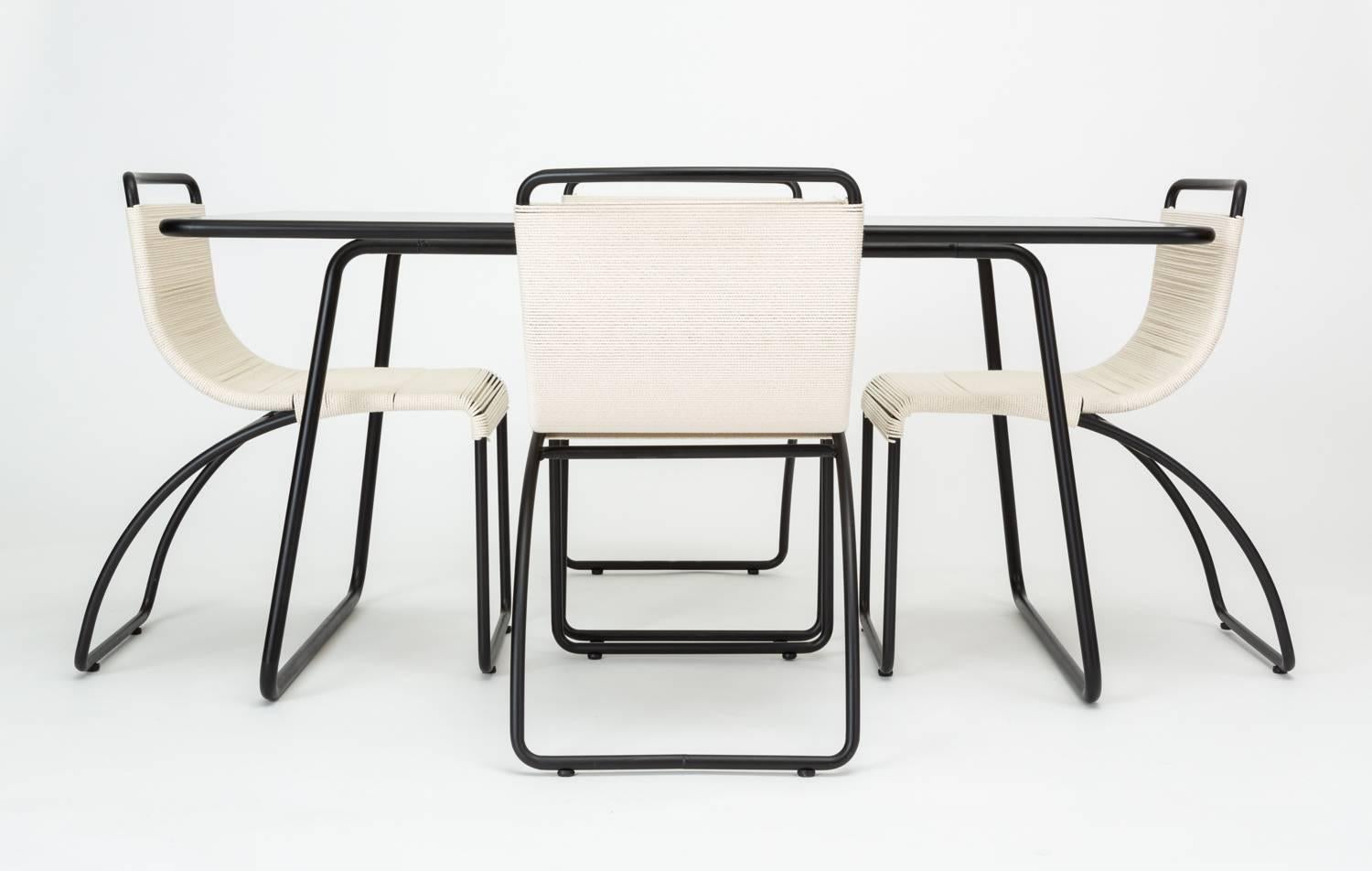 Designed by Hendrik Van Keppel and Taylor Green to suit indoor dining needs as well as outdoor, this patio dining set has four chairs and a rectangular table with a hammered glass top. Each chair has a slightly curved frame of tubular, powder-coated