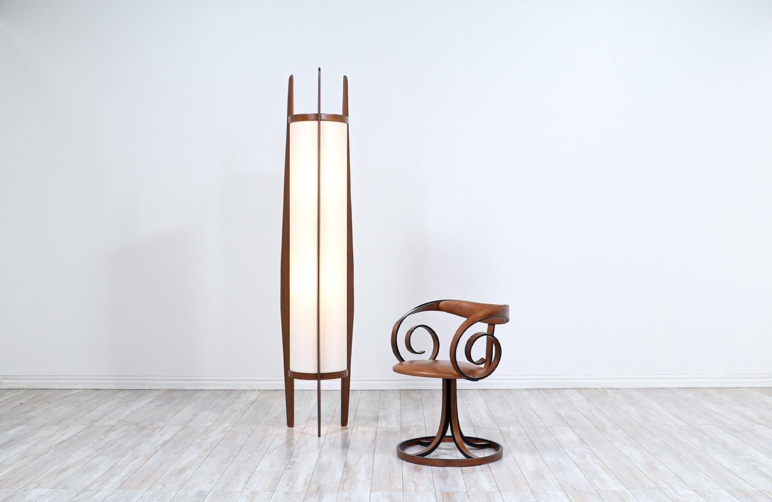 Dazzling vintage floor lamp designed and manufactured by Modeline of California circa 1960s. This exceptional hand-sculpted floor lamp features a tall sculpted walnut wood body with three asymmetrical arms that go up the body frame holding the new