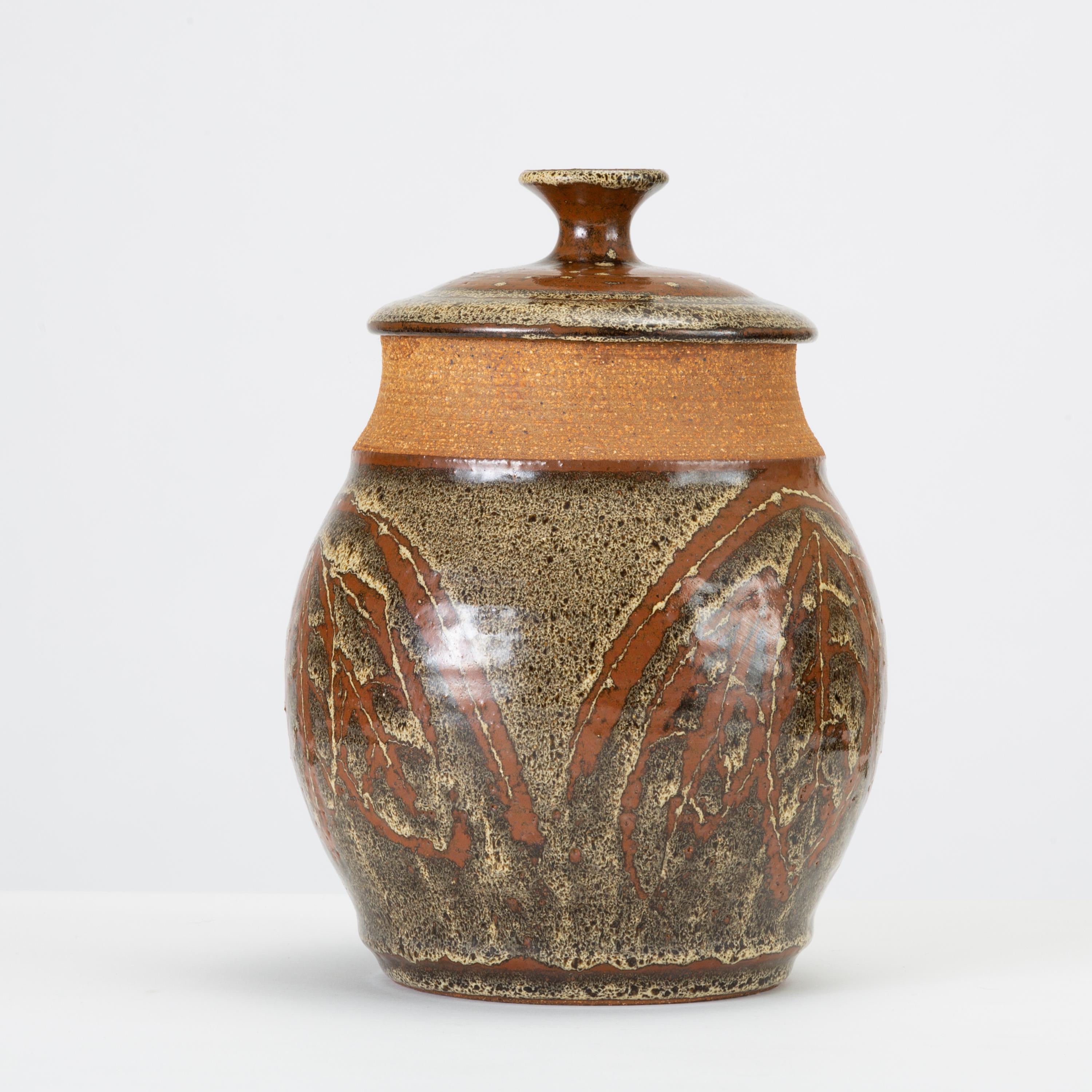 Don Jennings, a prominent local ceramicist based in Orange County, California, worked as an instructor and artist throughout the 1960s and 1970s. This example is a wheel-thrown ceramic lidded jar with a painted leaf pattern in high-gloss glaze - a