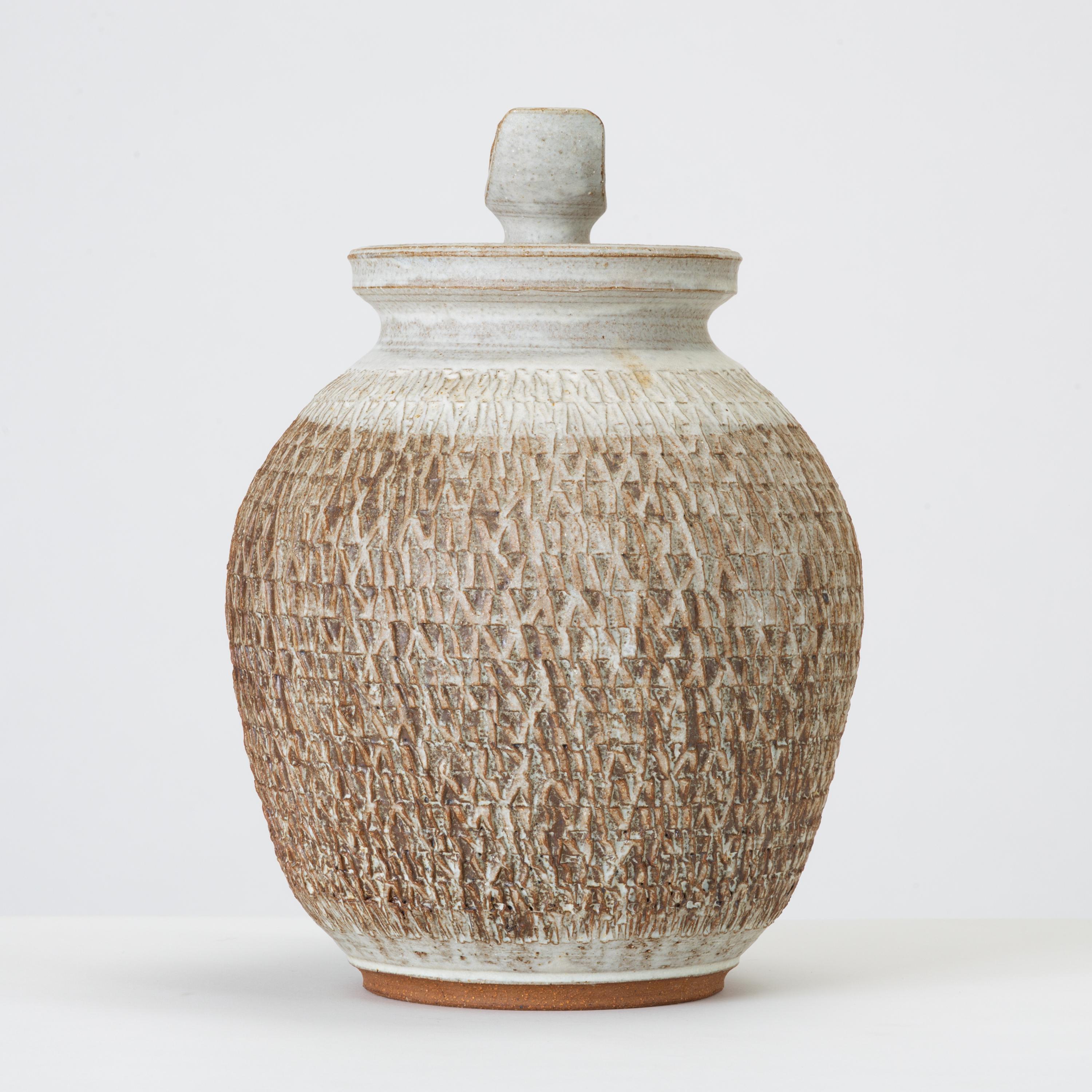 Don Jennings, a prominent local ceramicist based in Orange County, California, worked as an instructor and artist throughout the 1960s and 1970s. This example is a wheel-thrown ceramic lidded jar with a pleasing neutral palette of bone and chestnut