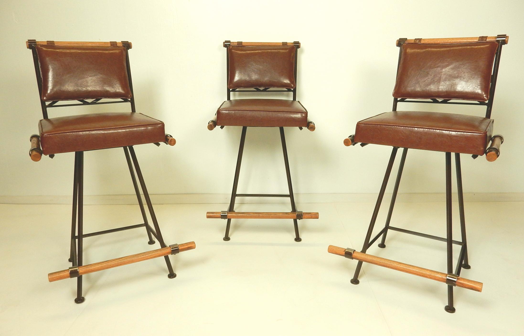 Fabulous set of 3 brown iron, wood and faux leather bar stools by Inca of California.
In the style of Cleo Baldon design, these are heavy overbuilt iron stools with oakwood rails and foot rests.
Newly upholstered in leather like brown vinyl.