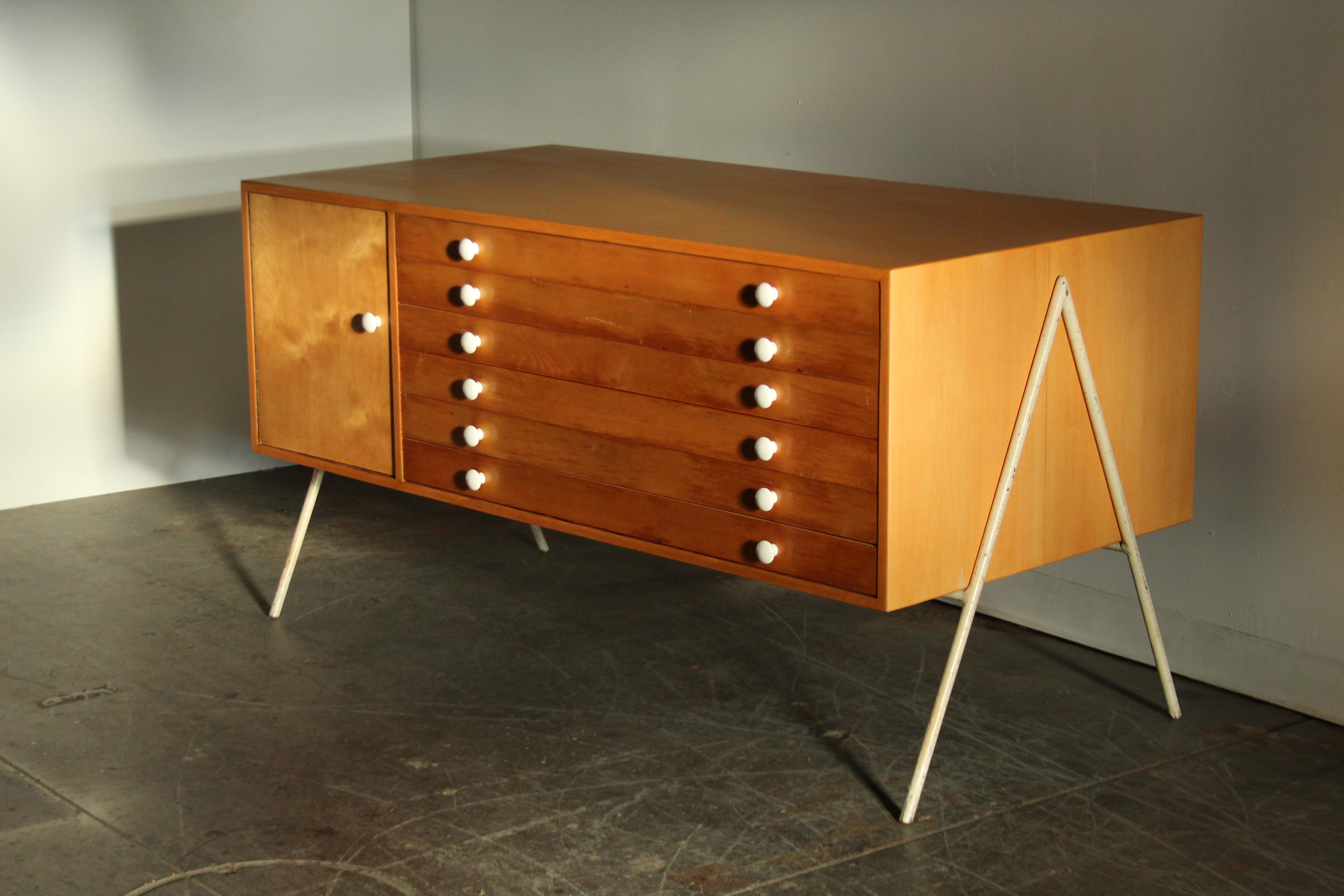 Interesante mueble de arquitecto modernista californiano de los años 50, formado por una gran caja de madera que flota sobre una base angular de hierro. También podría ser una fantástica isla de cocina. Toneladas de almacenamiento. El mueble se ha