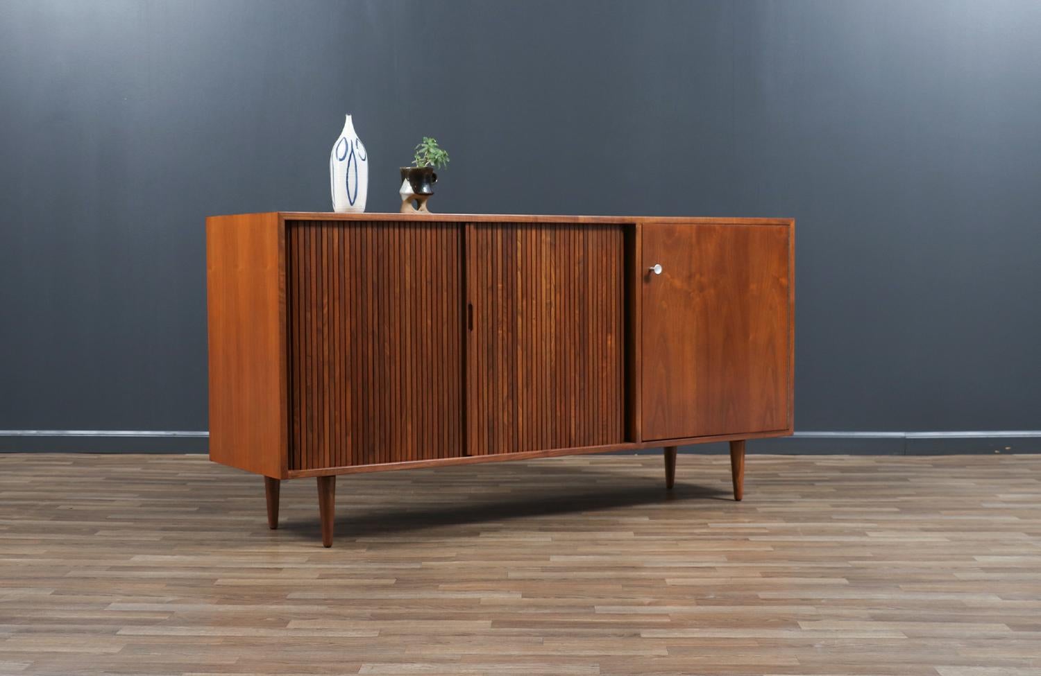 Credenza Mid Century Modern progettata da Milo Baughman per Glenn of California negli Stati Uniti, negli anni '50 circa. Sostenuto da gambe affusolate e realizzato con una struttura in noce e due ante a battente che si aprono dolcemente per rivelare