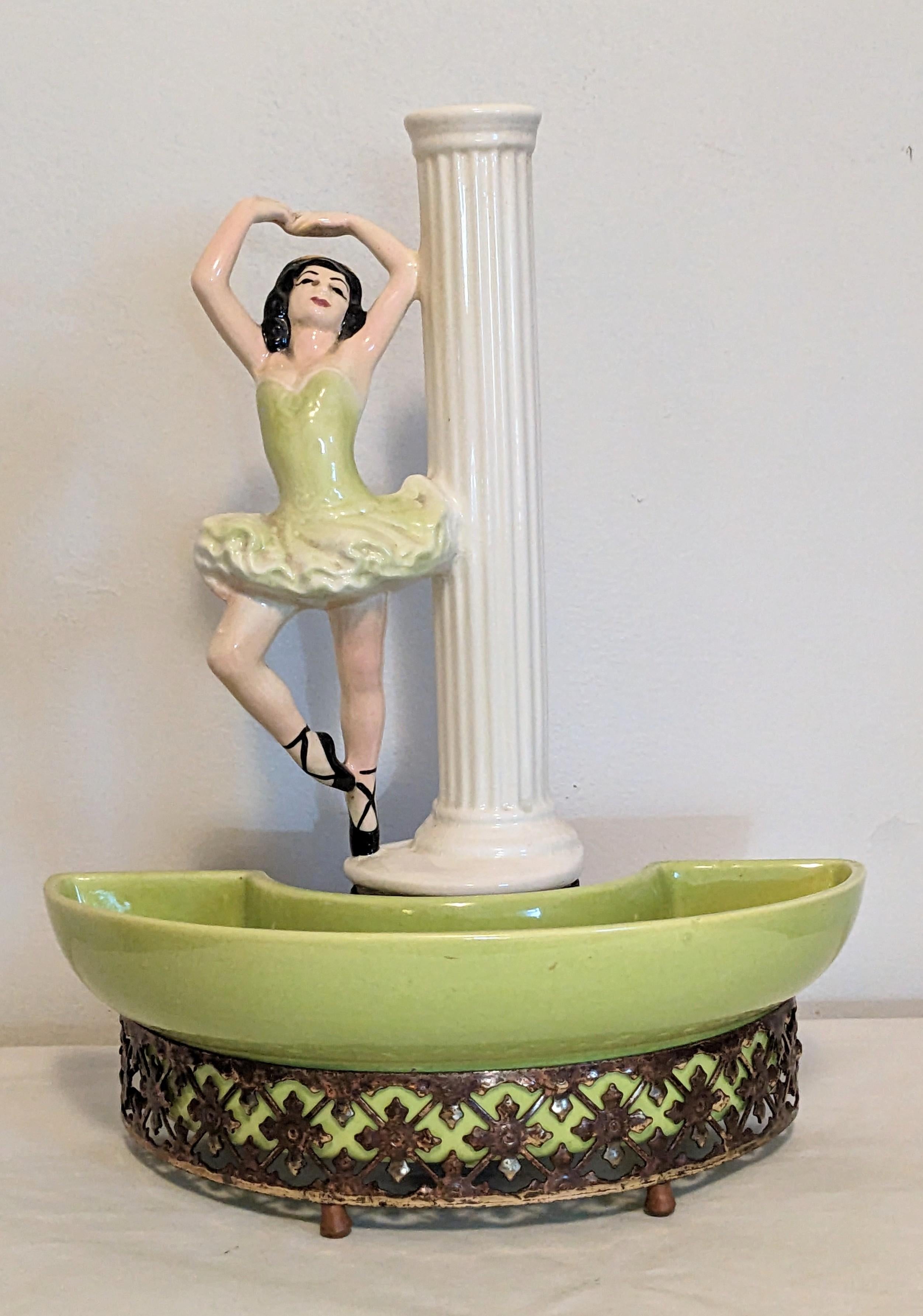 California Pottery Ballerina TV lamp from the 1950's by the Sierra Columbia Pottery Company of Pasadena. Glazed pottery ballerina sits atop a lime pottery planter well which is back lit by a small bulb. 
Kitsch and amusing 1950's decor.
 