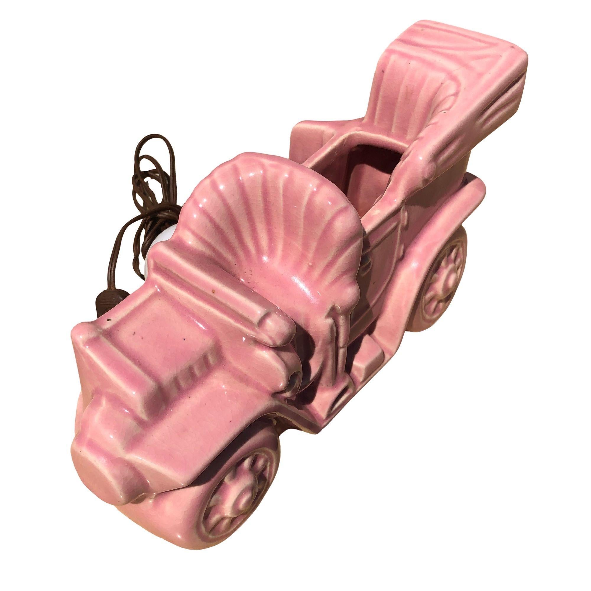 Original 1950s ceramic TV lamp with small bud planter showcasing an old-fashioned car like a Ford Model T by California ceramics and pottery maker Mcoy Pottery. The lamp is finished in pink embodying the elegance of mid-century color design.

After