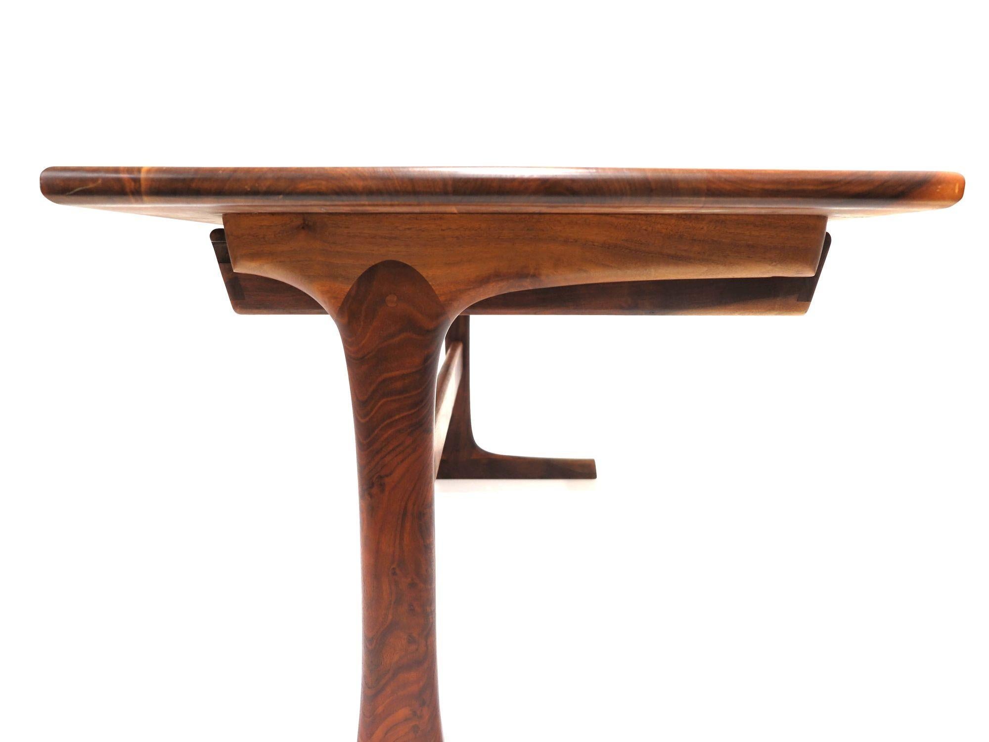 California studio desk handcrafted of solid black Walnut by Berkeley craftsman, Jim Sweeney. The desk features beautifully figured black walnut, two drawers with exposed joinery on sides, raised on sculptural pedestal base with cross stretcher. The