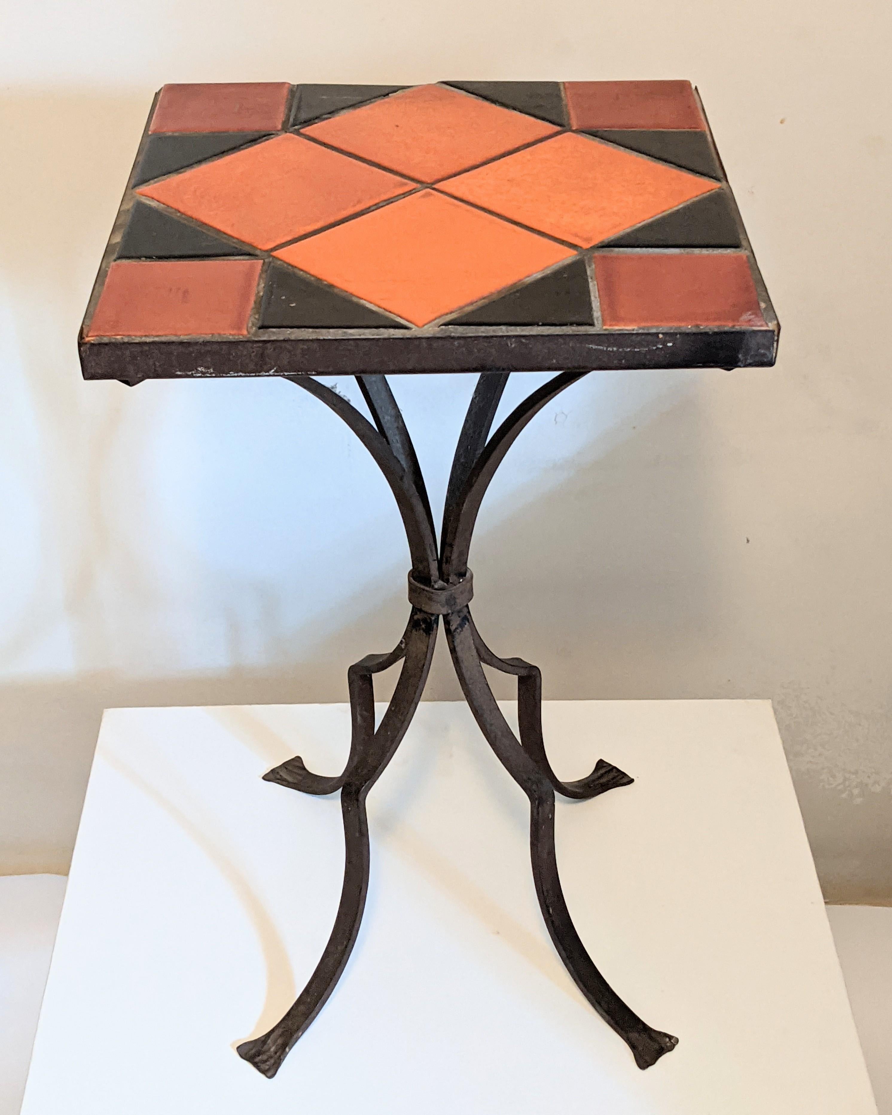 Decorative and charming California Tile Wrought Iron Table from the 1940's in tones of burnt orange and black. 12.75
