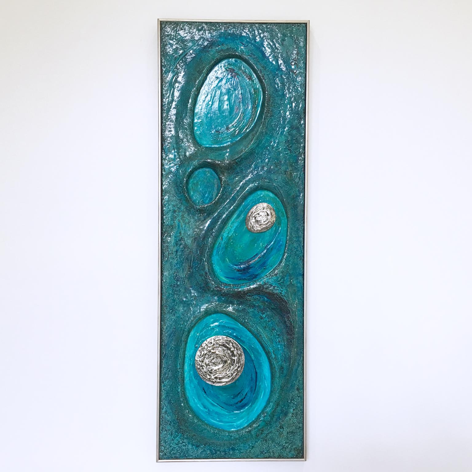 Californian artist Lorraine Stelzer created this mesmerizing psychedelic Pop Art composition in 1969. This mid-century modern dimensional wall sculpture panel is in resin and features a beautiful bright turquoise color range with silver accents.