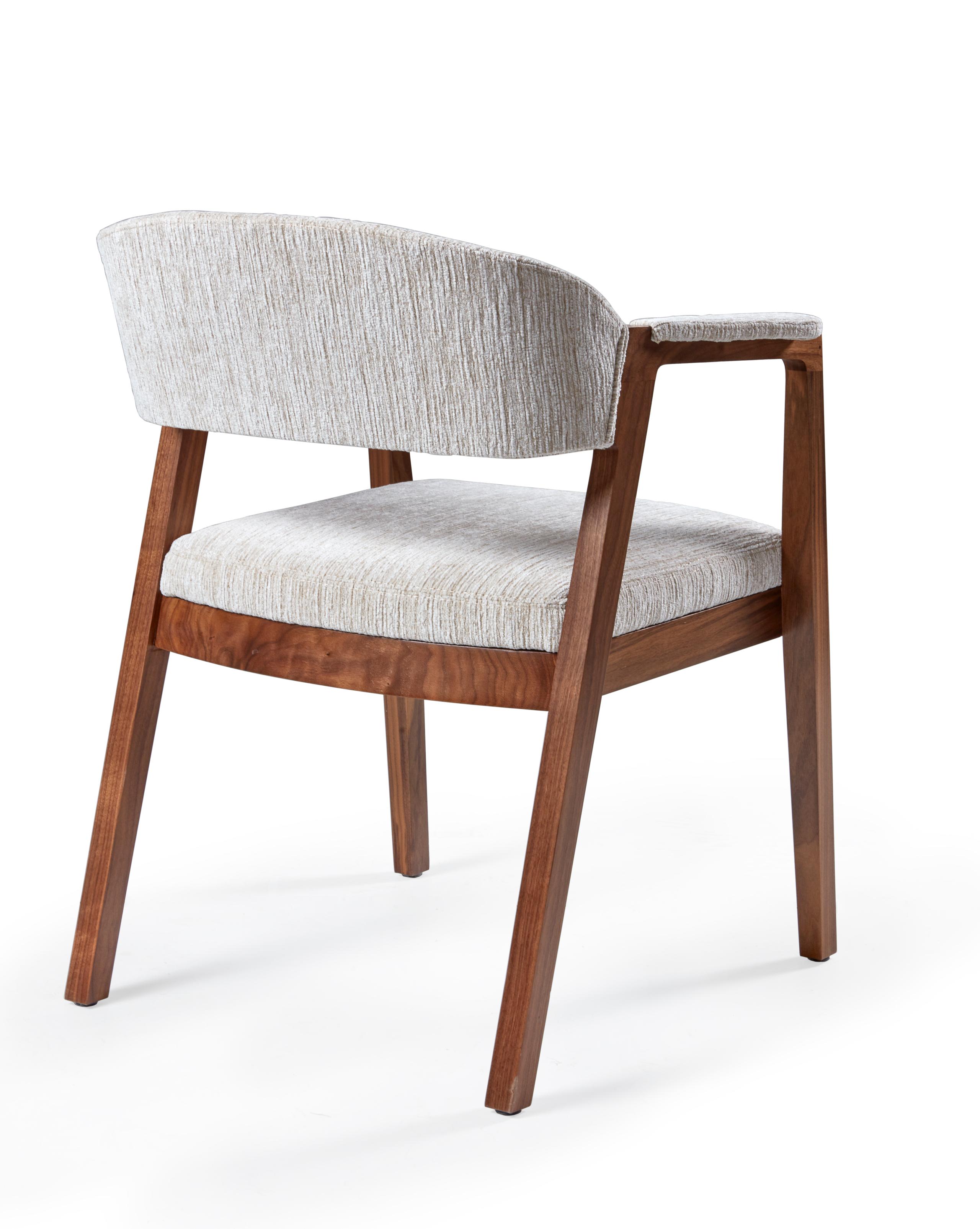 This sleek armed dining chair features an upholstered back and seat with the perfect pitch, assuring both your style and comfort are elevated.