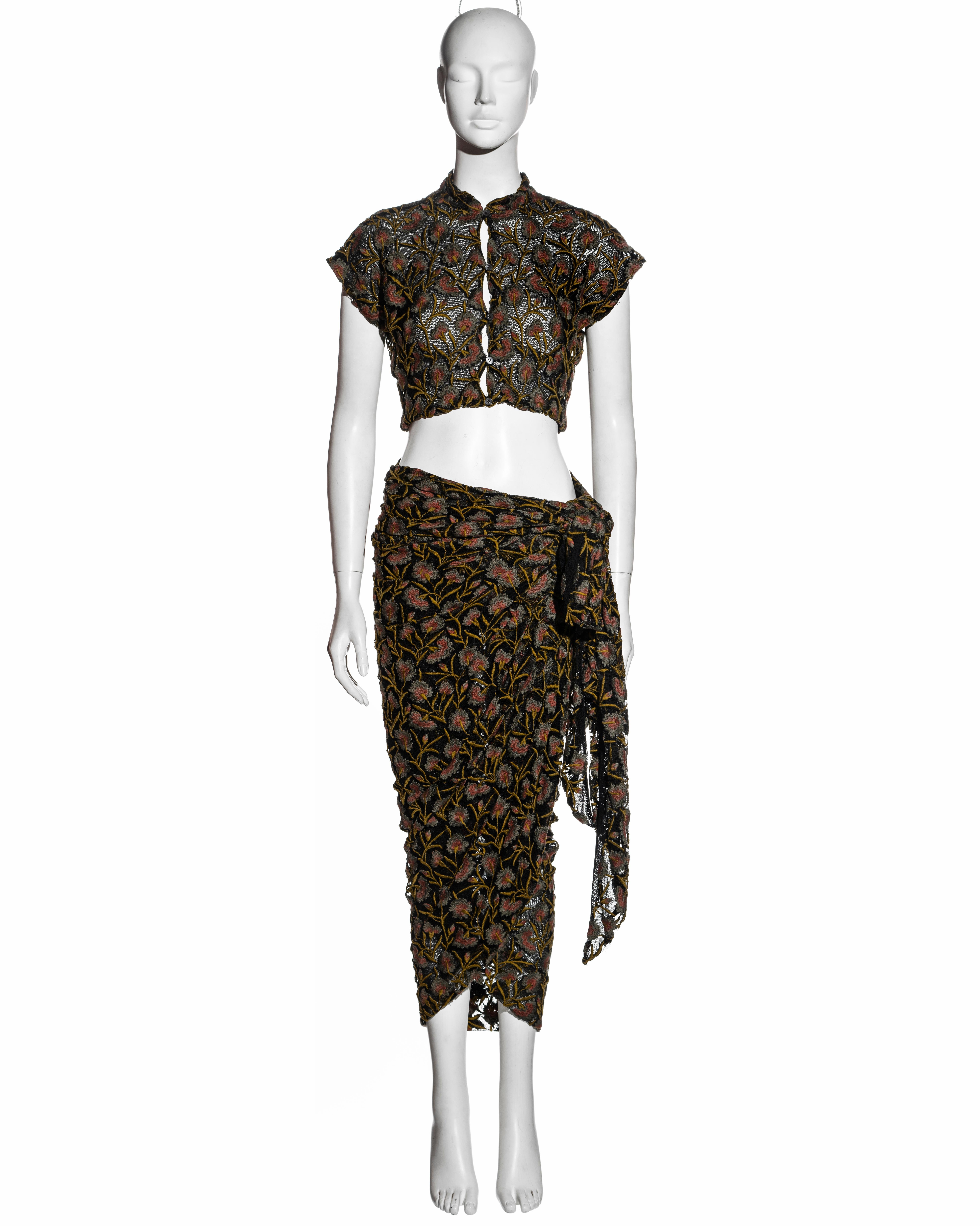 ▪ Callaghan blouse and skirt set
▪ Designed by Romeo Gigli
▪ Black cotton-mesh with intricate floral embroidery allover 
▪ Cropped button-up blouse with cap sleeves 
▪ Circular cut wrap skirt with long ties which bind around the waist 
▪ IT 40 - FR