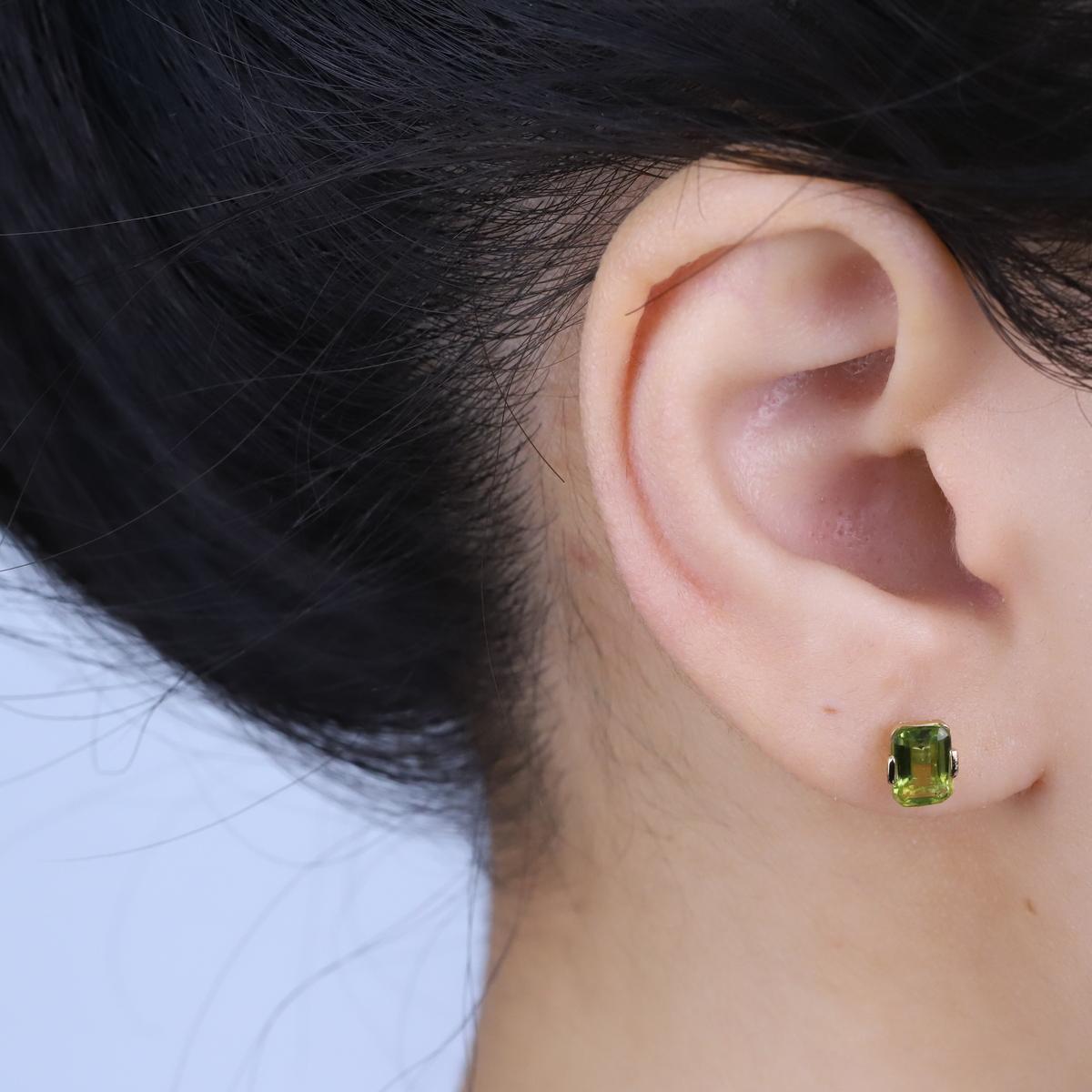 Schmücken Sie sich mit Eleganz mit diesem Ohrring aus 10-kar�ätigem Gelbgold von Gin & Grace Earring. Dieser Ohrring besteht aus einem Peridot im Smaragd-Schliff (2 Stück) von 2,04 Karat. Dieser Ohrring wiegt 0.84 Gramm. Dieser zarte Ohrring ist auf