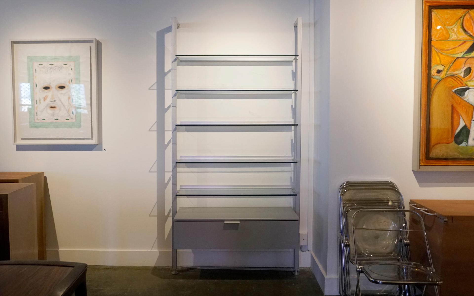 Single Bay wall shelving unit by Calligaris, Italy, 1970s.  Each piece of glass is signed Calligaris Tempered.  Completely original.  The frame / supports are solid brushed aluminum.  The drawers section is silver / gray lacquered wood.  The glass