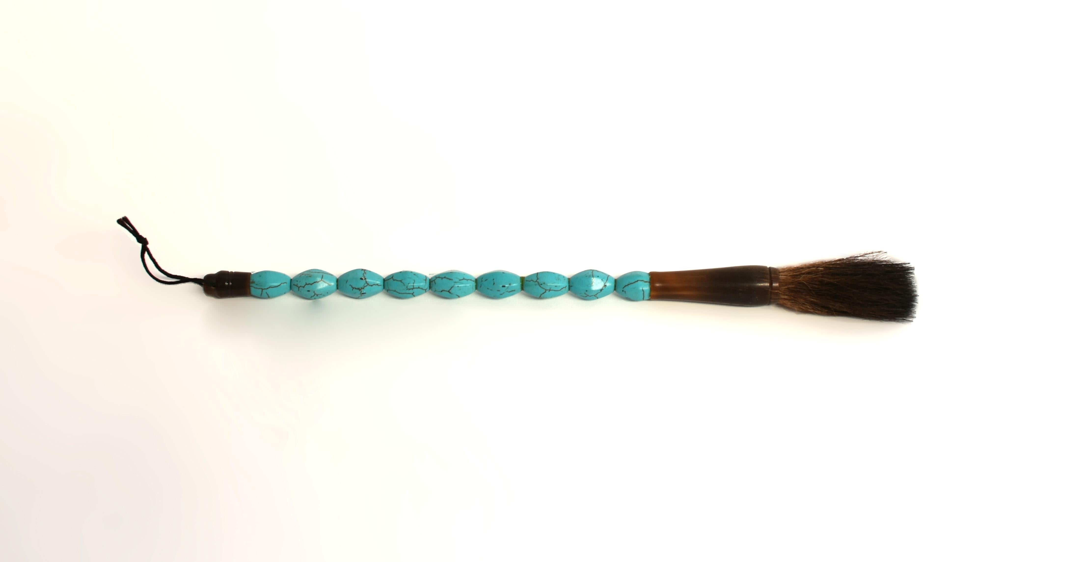 This calligraphy brush is distinguished by its faux turquoise handle. Hand cut and polished, exhibiting a beautiful turquoise color with naturalistic black veining, very much approximating the appearance of genuine turquoise. The brush is fitted