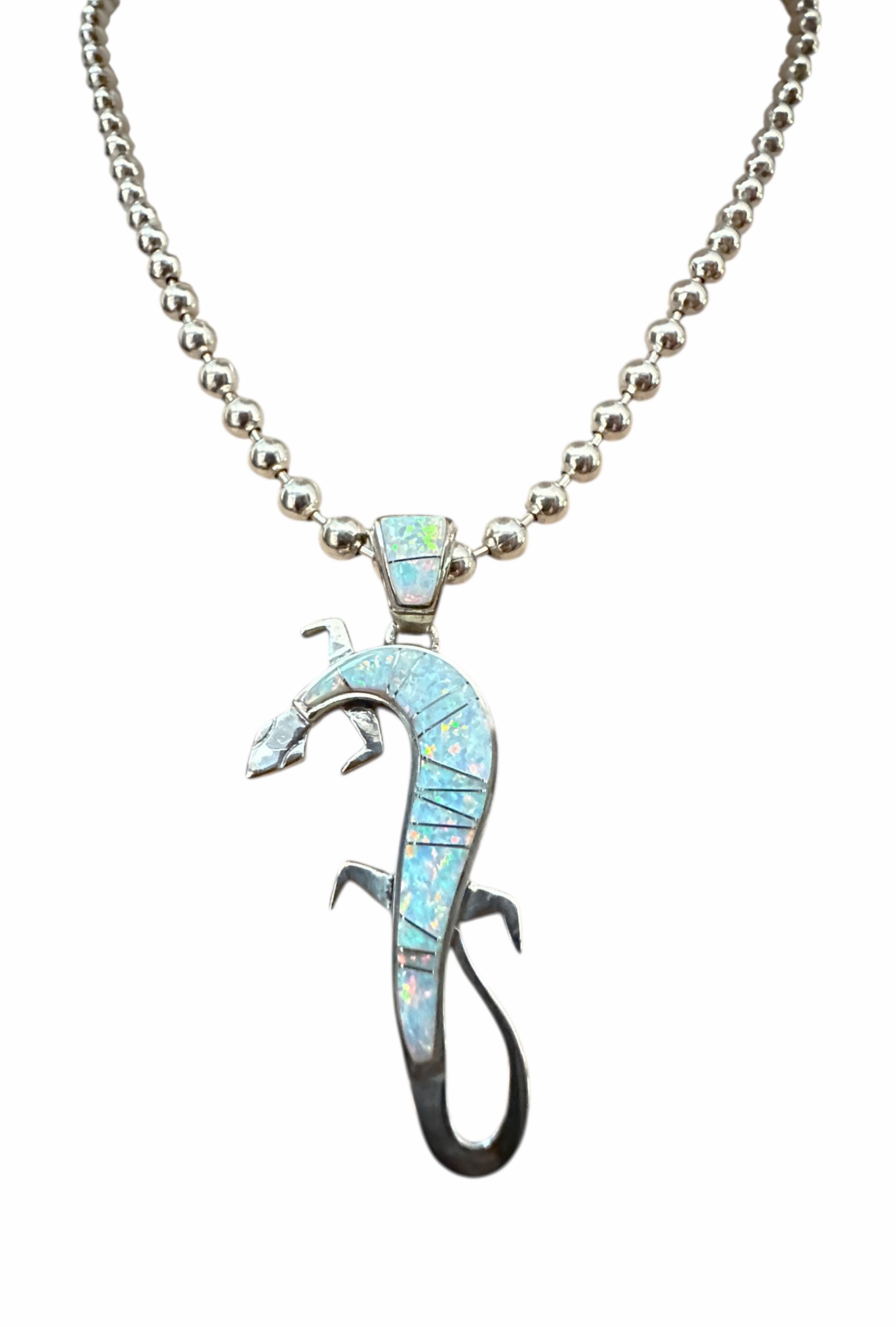 Si tratta di un bellissimo ciondolo disegnato dall'artista Navajo Calvin Begay.  Si tratta di un pezzo di qualità, come tutti i gioielli di Begay.  Le pietre sono opali di fuoco e di ghiaccio e sono intarsiate tra nastri di argento sterling. Il