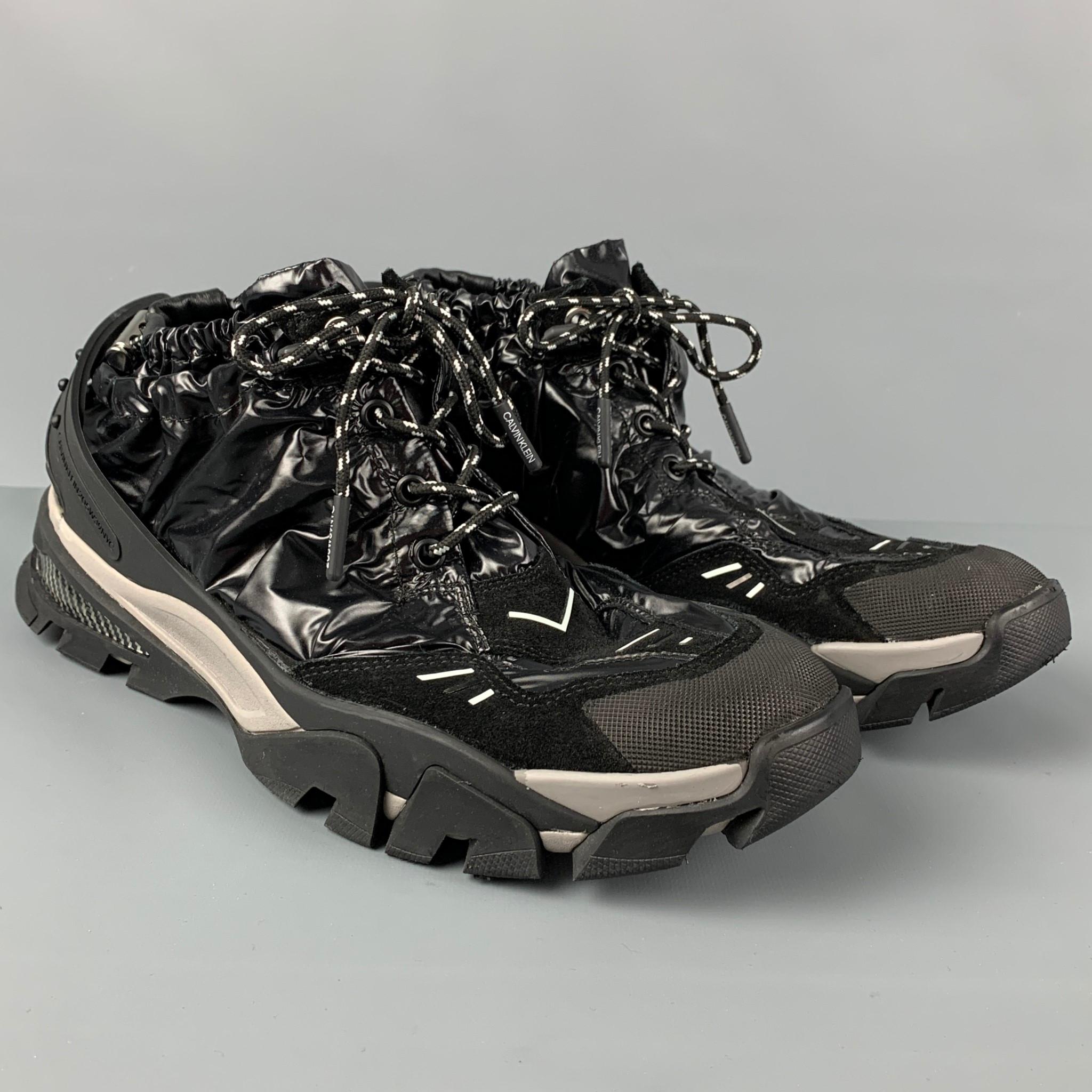CALVIN KLEIN 205W39NYC sneakers comes in a black & grey nylon featuring a suede trim,  drawstring detail, detachable back strap, and a lace up closure. Includes box. 

Excellent Pre-Owned Condition.
Marked: 12.5
Original Retail Price: