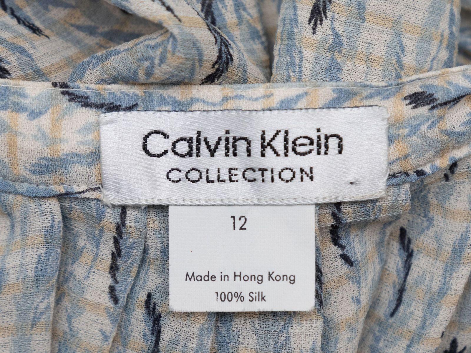 Product Details: Vintage light blue and multicolor printed silk skirt by Calvin Klein Collection. Button closures at center front. 28