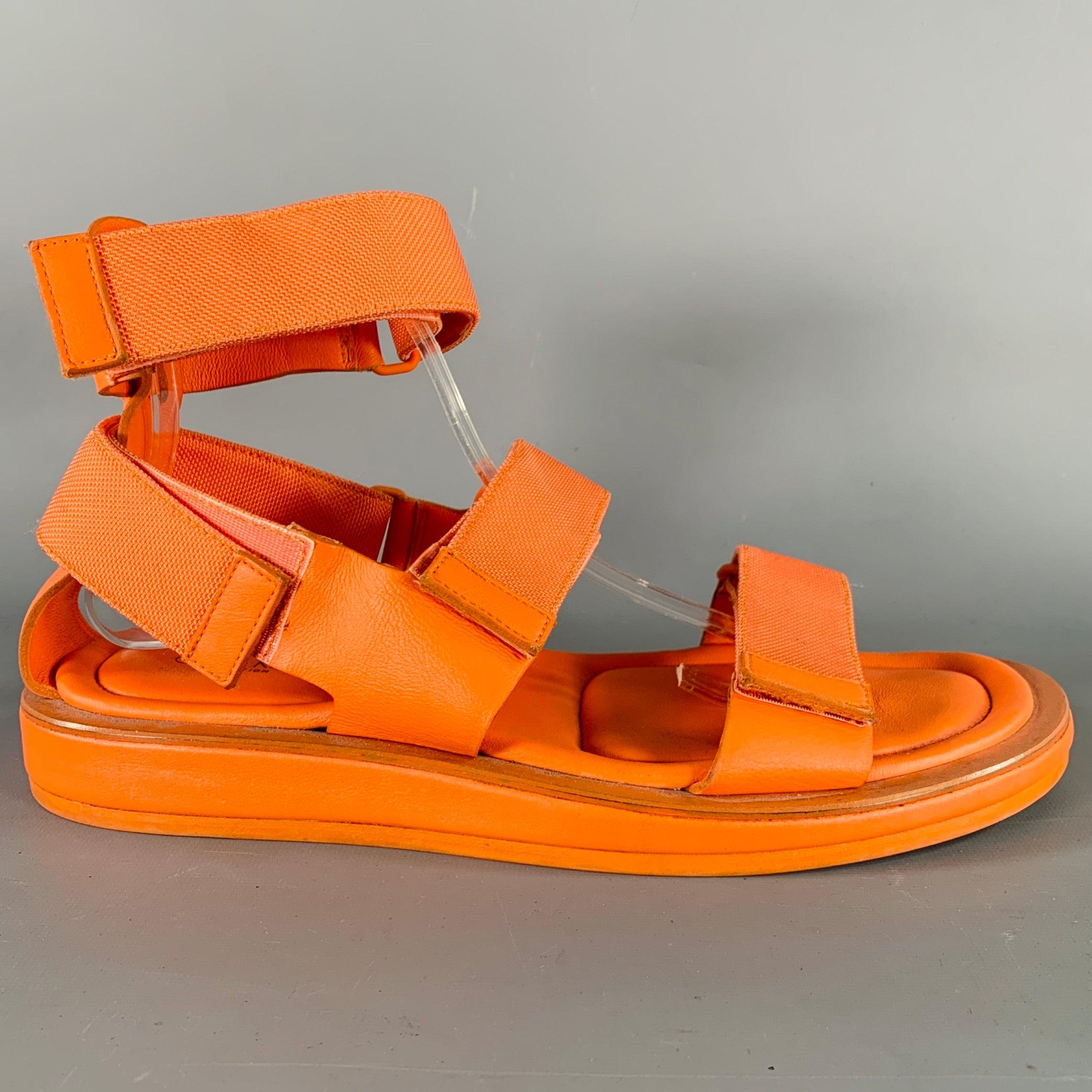 CALVIN KLEIN COLLECTION sandals in an orange leather featuring an ankle strap, hook & loop closure, and a rubber sole. Made in Italy.Good Pre-Owned Condition. Moderate wear throughout. 

Marked:   7507 11Outsole: 12 inches  x 5 inches  
  
  
 
Sui
