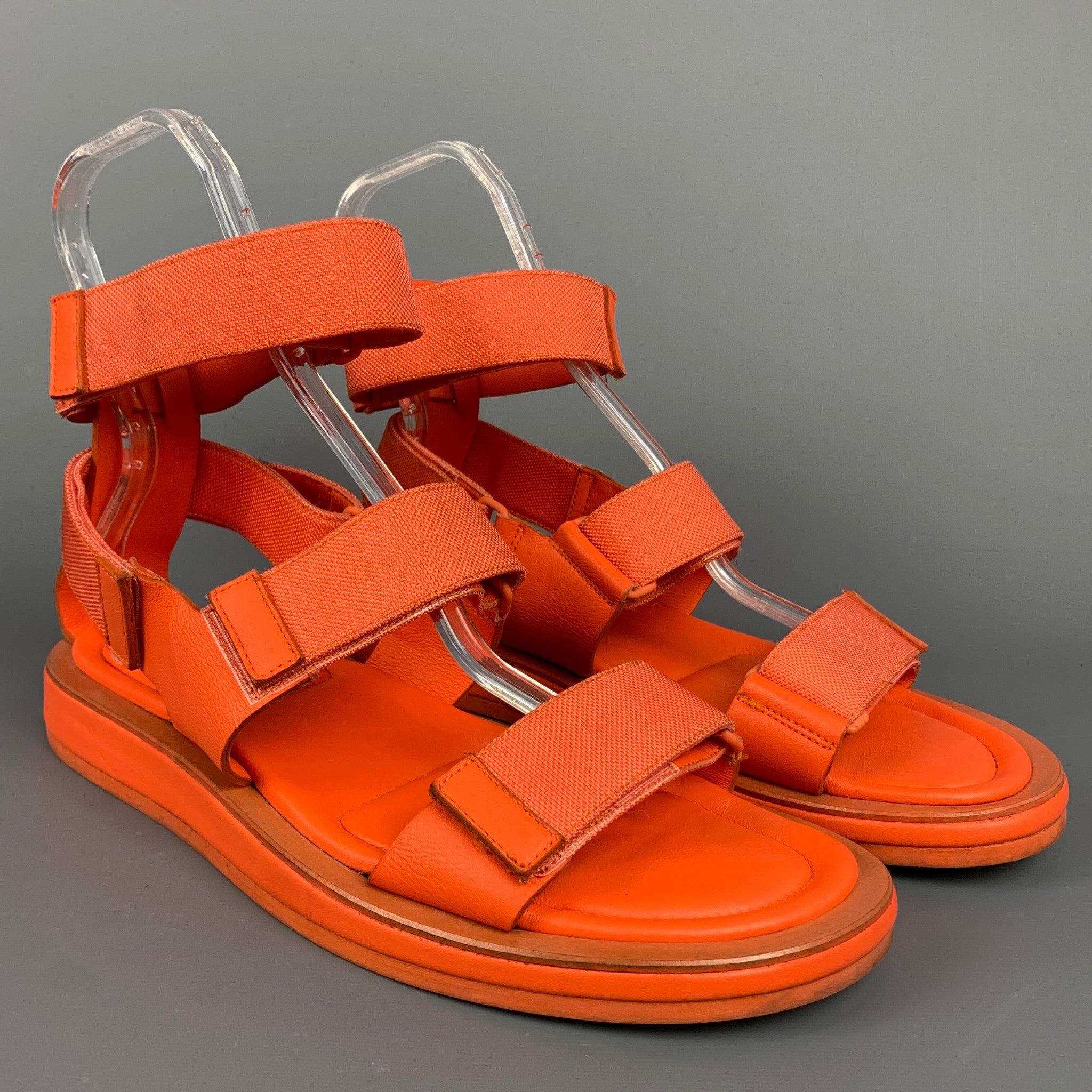 CALVIN KLEIN COLLECTION sandals comes in a orange leather featuring a ankle strap, hook & loop, and a rubber sole. Made in Italy.Good
 Pre-Owned Condition.
 Moderate wear throughout.  
 

 Marked:  7507 11Outsole: 12 inches x 5 inches 
  
  
  
 Sui