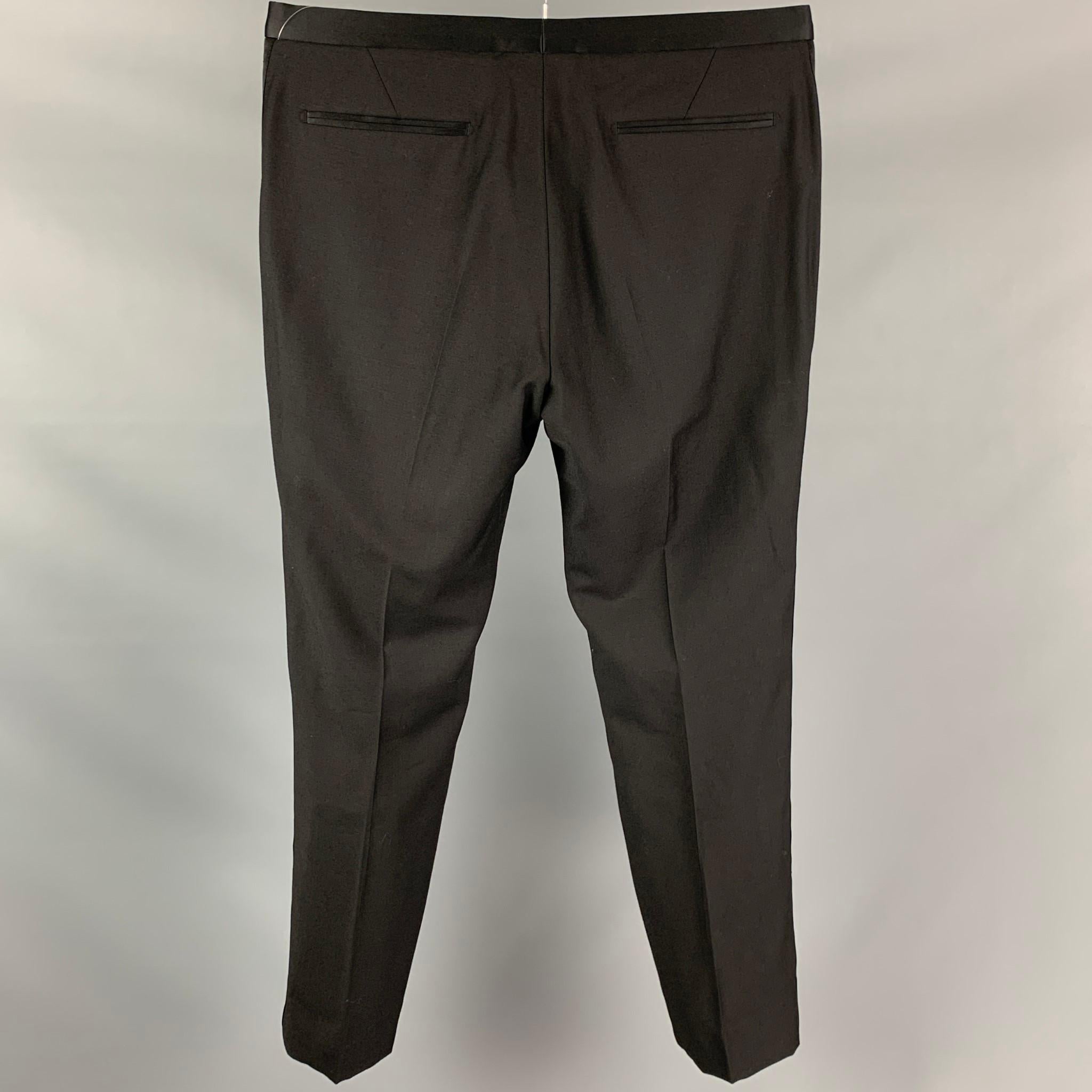 CALVIN KLEIN COLLECTION dress pants comes in a black wool featuring a flat front, slit pockets, front tab, and a zip fly closure.

Very Good Pre-Owned Condition.
Marked: 50/40

Measurements:

Waist: 34 in.
Rise: 10 in.
Inseam: 29 in.   