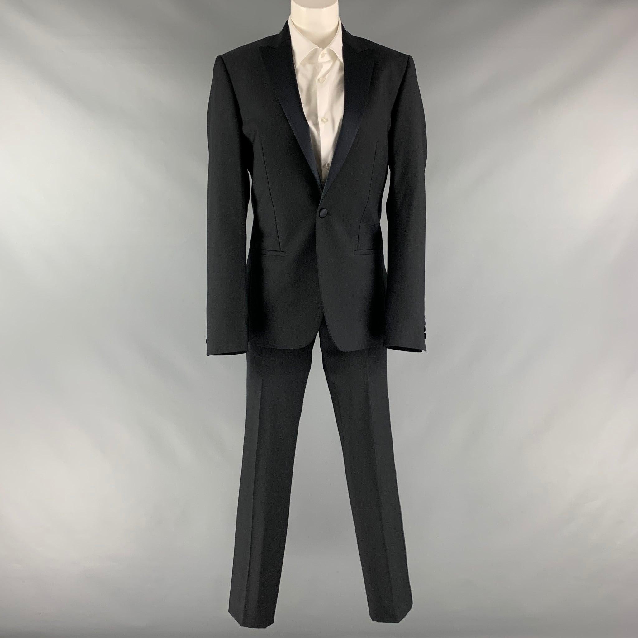 CALVIN KLEIN COLLECTION suit comes in a black wool material with a full liner and includes a single breasted, single button sport coat with a peak lapel and matching flat front tuxedo style trousers. Made in Italy.Excellent Pre-Owned Condition.