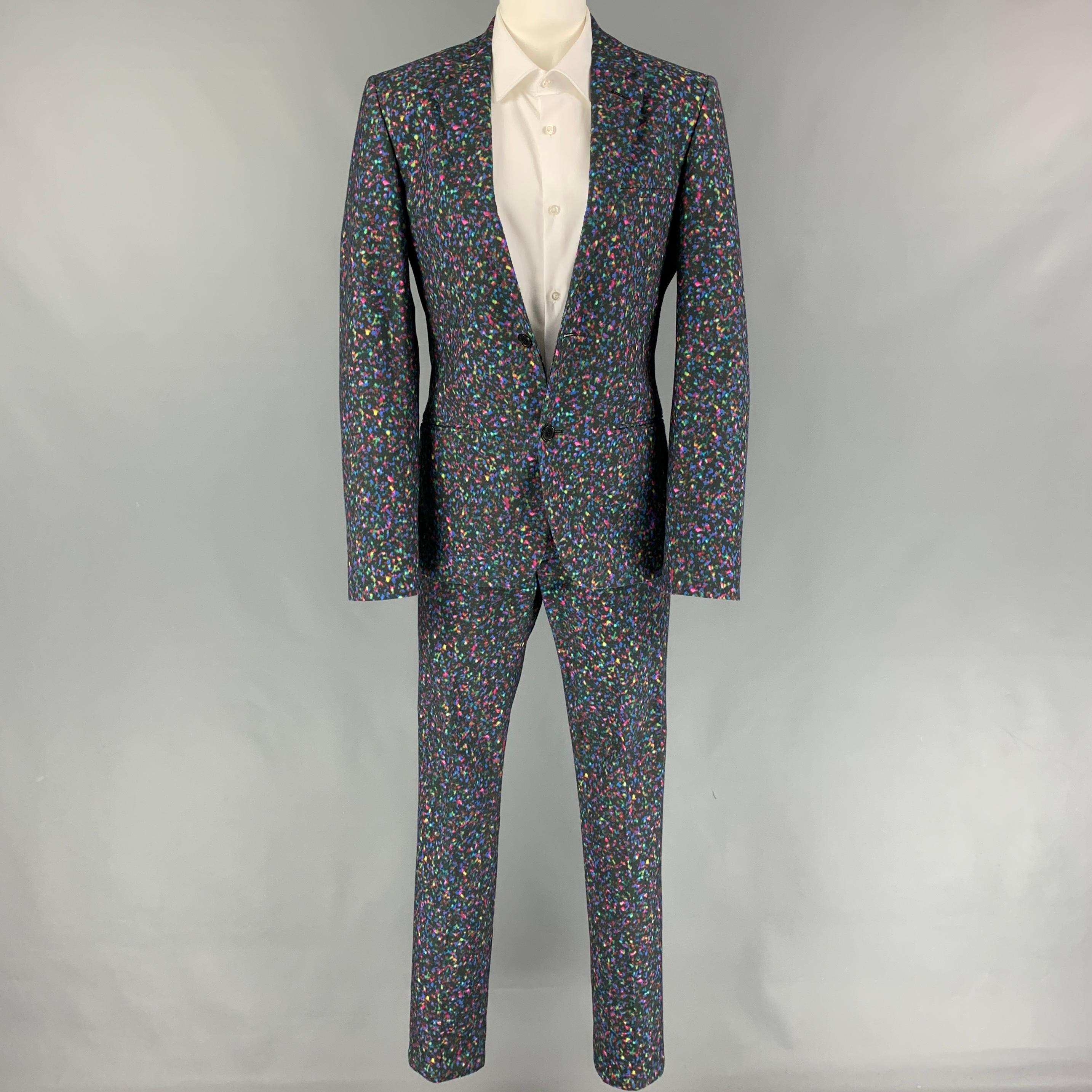 CALVIN KLEIN COLLECTION suit comes in a multi-color print cotton and includes a single breasted, double button sport coat with a notch lapel and matching flat front trousers.

Very Good Pre-Owned Condition.
Marked: