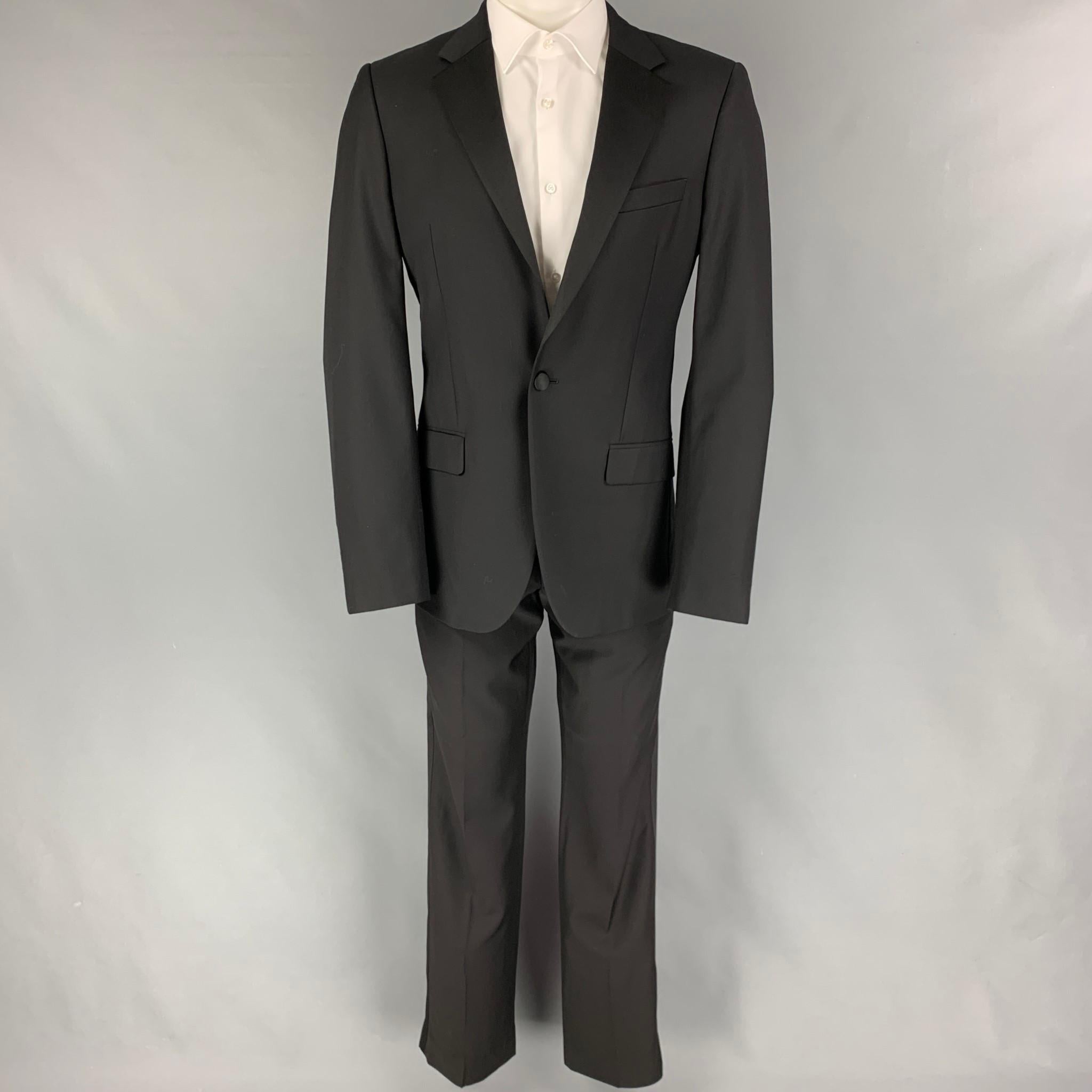 CALVIN KLEIN COLLECTION suit comes in a black wool with a full liner and includes a single breasted, single button sport coat with a notch lapel and matching flat front trousers.

Very Good Pre-Owned Condition.
Marked: