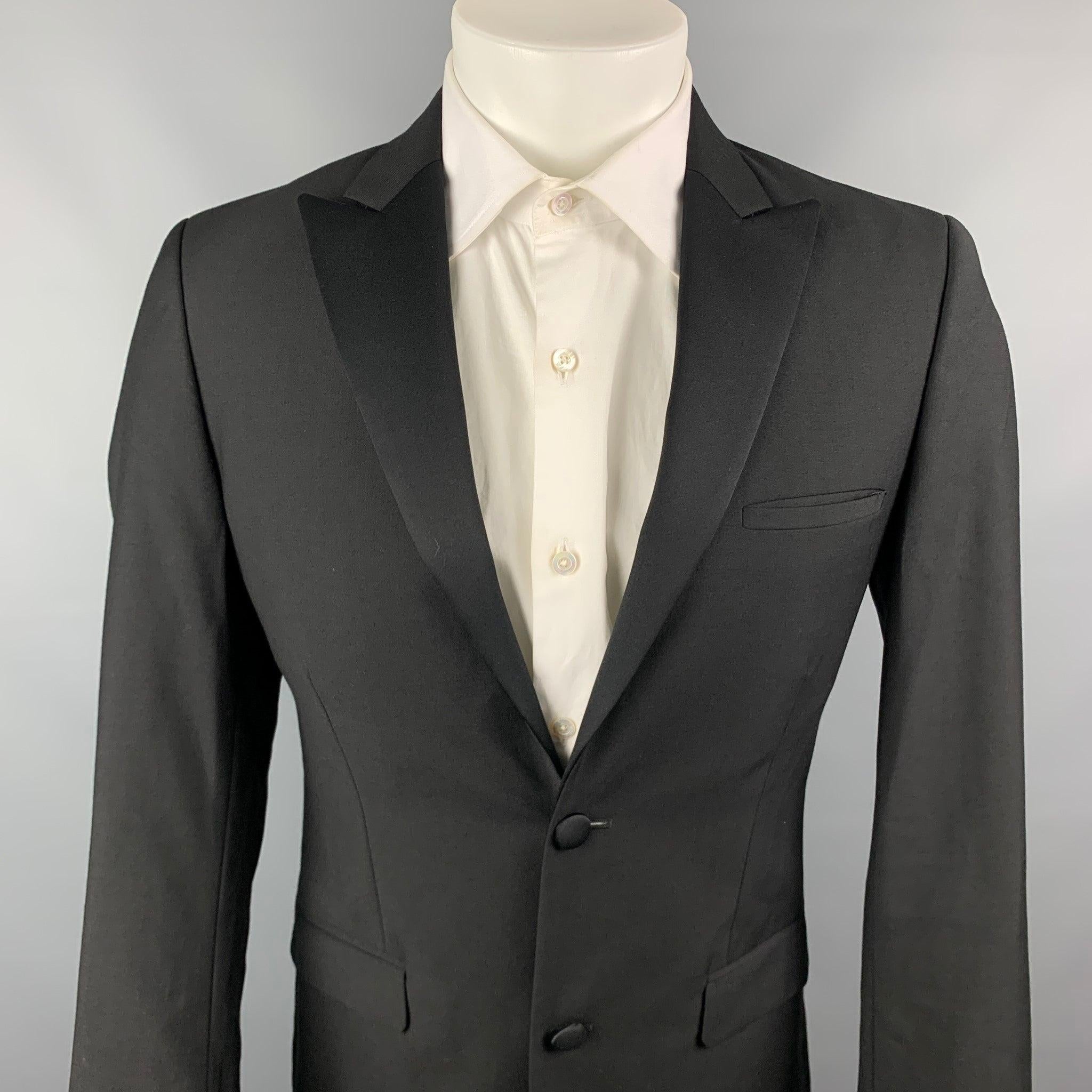 CALVIN KLEIN COLLECTION tuxedo sport coat comes in a black wool with a full liner featuring a
peak
lapel, flap pockets, and a double button closure.
Very
Good
Pre-Owned Condition. 

Marked:   46 

Measurements: 
 
Shoulder: 17
inches