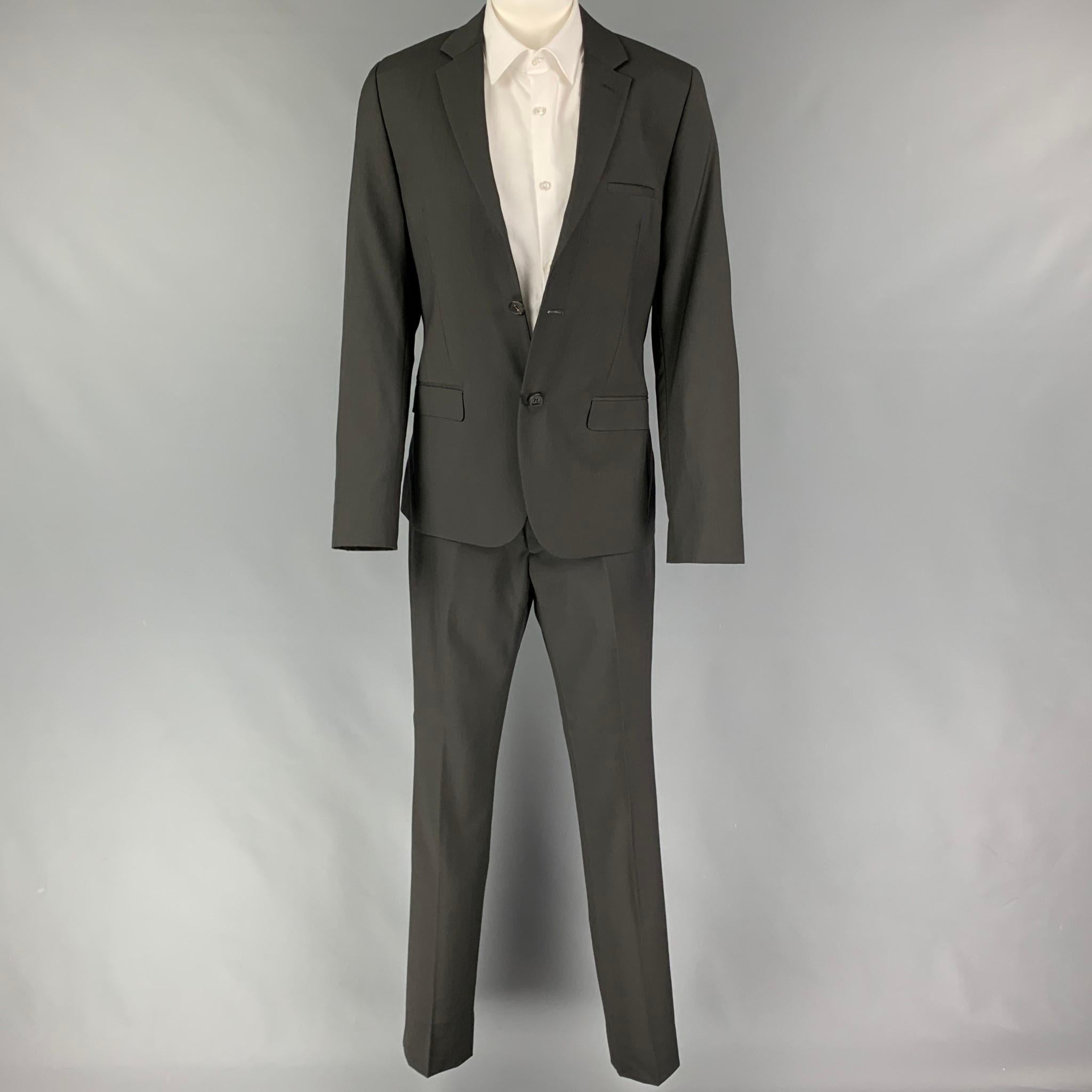 CALVIN KLEIN COLLECTION suit comes in a charcoal wool  with a full liner and includes a single breasted,  double button sport coat with a notch lapel and matching flat front trousers.

New With Tags.
Marked: 46/36
Original Retail Price: