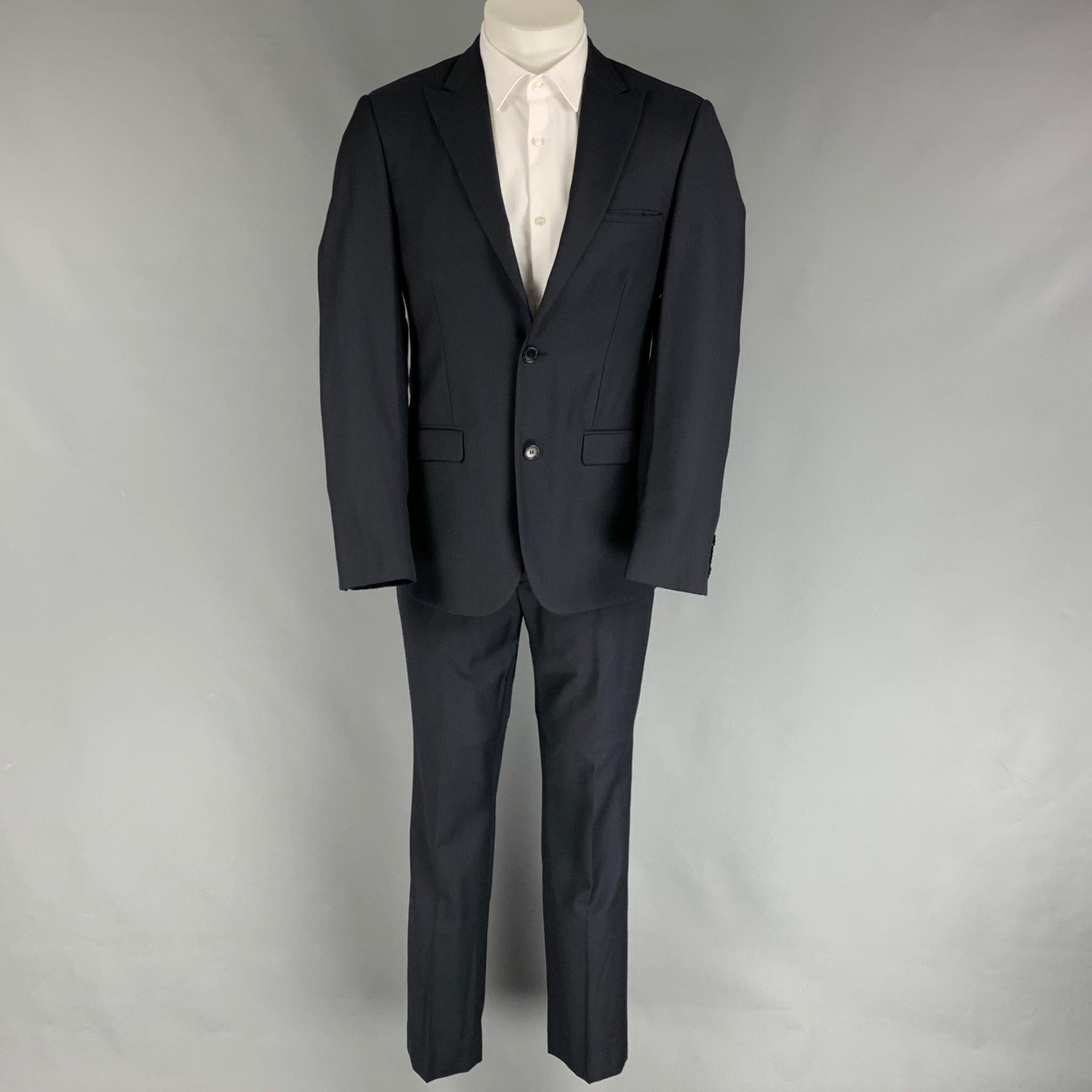 CALVIN KLEIN COLLECTION
suit comes in a navy grid wool with a full liner and includes a single breasted, double button sport coat with a peak lapel and matching flat front trousers. Very Good Pre-Owned Condition. 

Marked:   46/36 

Measurements: 
 