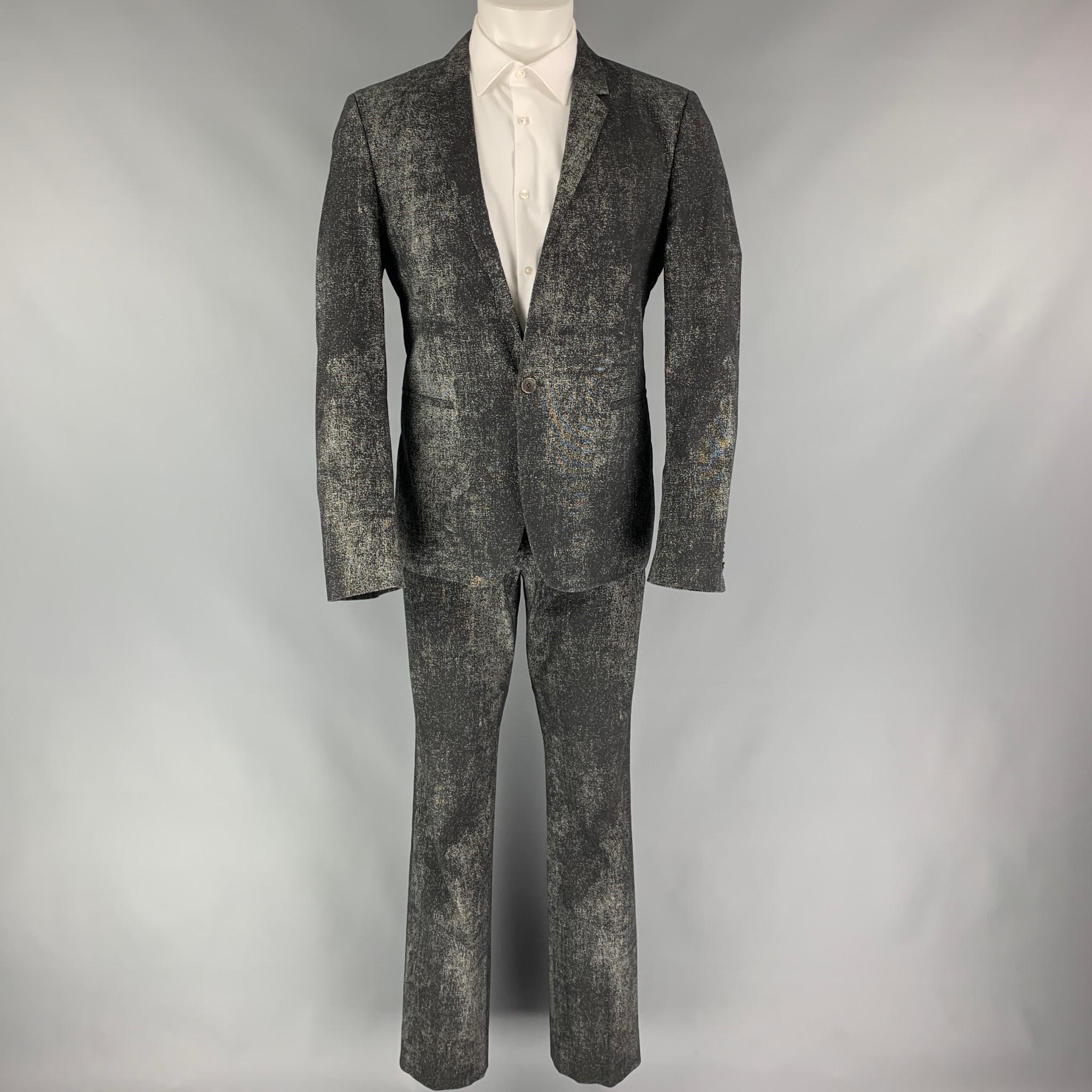 CALVIN KLEIN COLLECTION suit comes in a black & grey splattered cotton blend with a full liner and includes a single breasted, single button sport coat with a notch lapel and matching flat front trousers.

Very Good Pre-Owned Condition.
Marked: