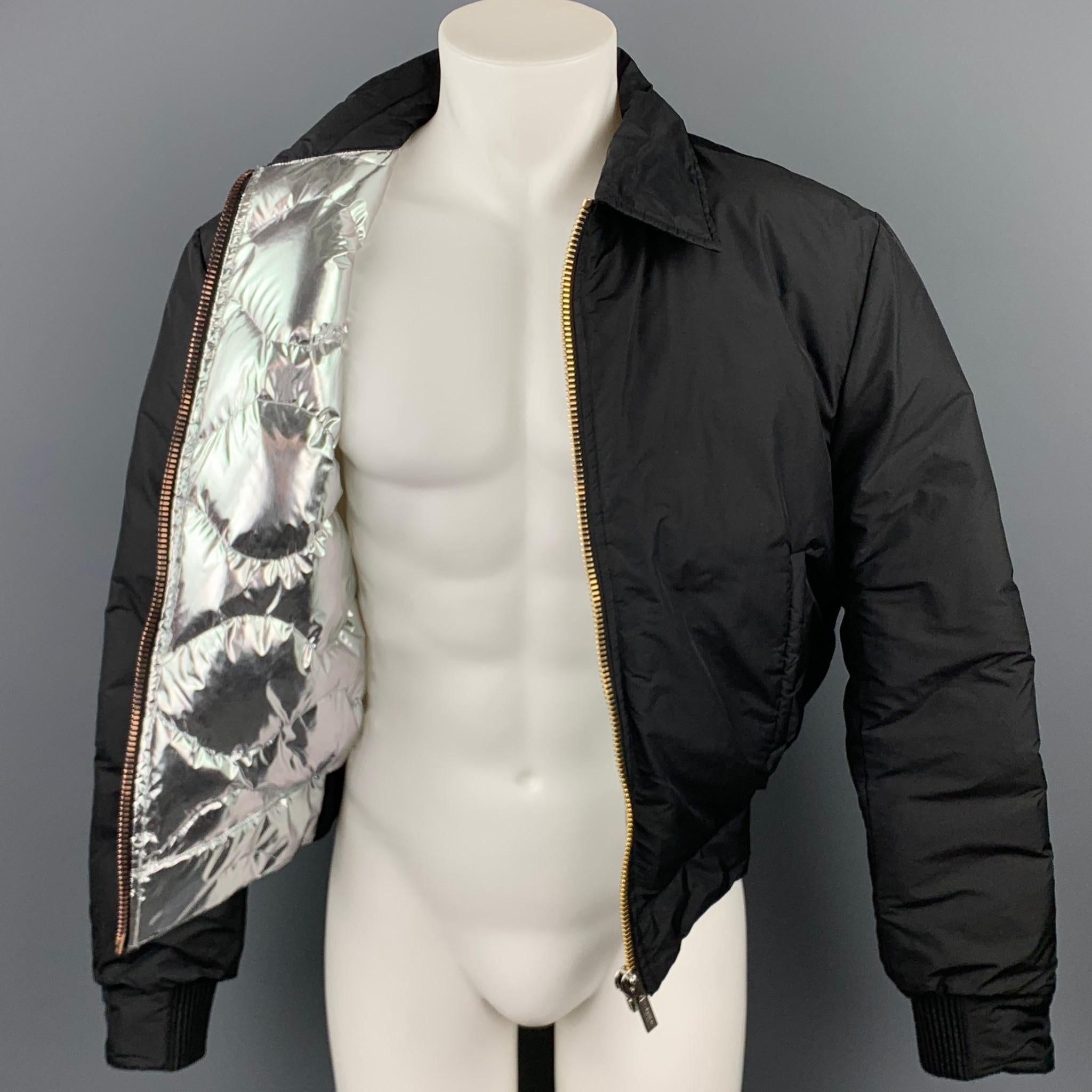 CALVIN KLEIN COLLECTION jacket comes in a black polyamide with a silver metallic quilted liner featuring a spread collar and a zip up closure. Minor discoloration throughout. Made in Italy.

Good Pre-Owned Condition.
Marked: