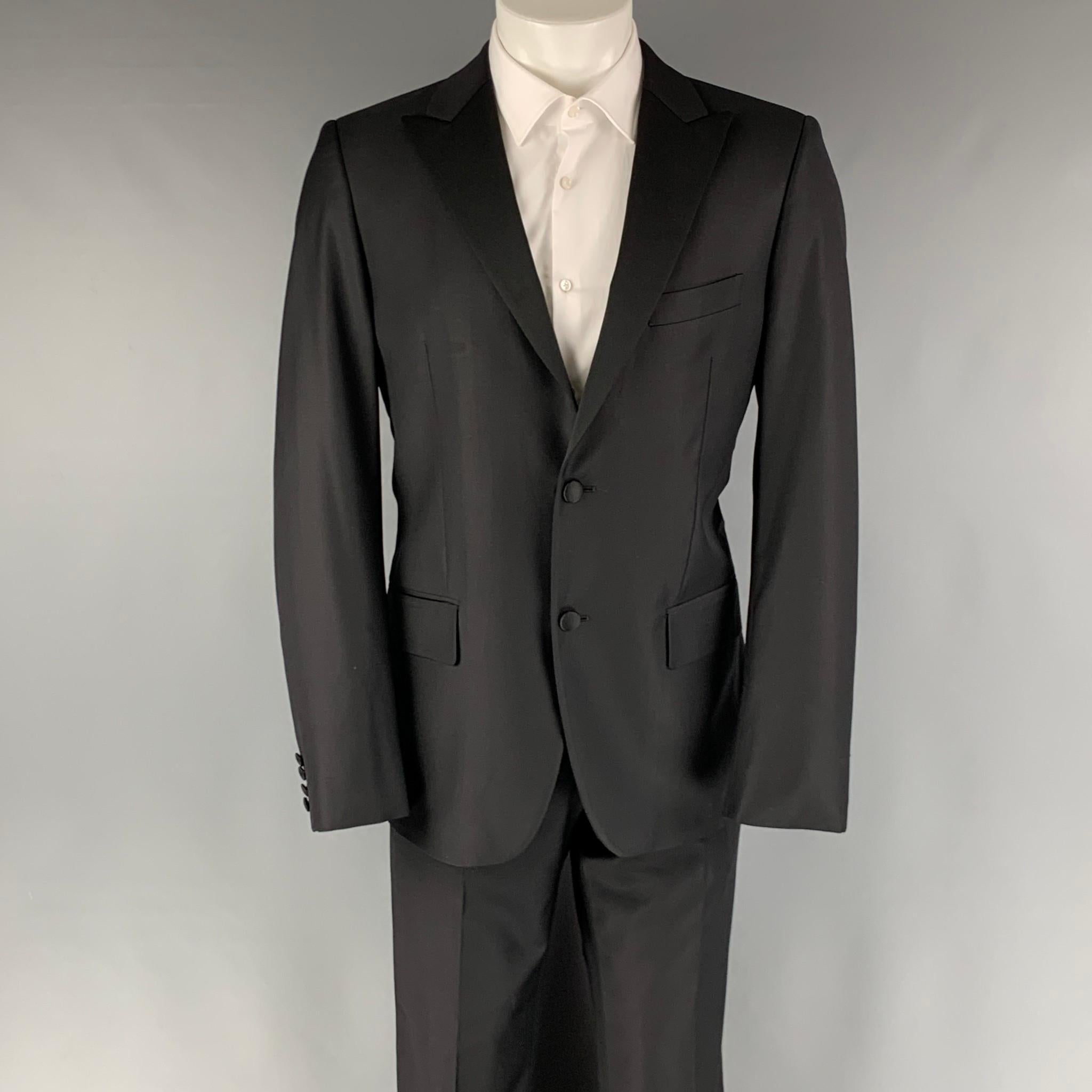 CALVIN KLEIN COLLECTION tuxedo comes in a black wool with a full liner and includes a single breasted, two buttons sport coat with a peak lapel and matching flat front trousers.

Excellent Pre-Owned Condition.
Marked:
