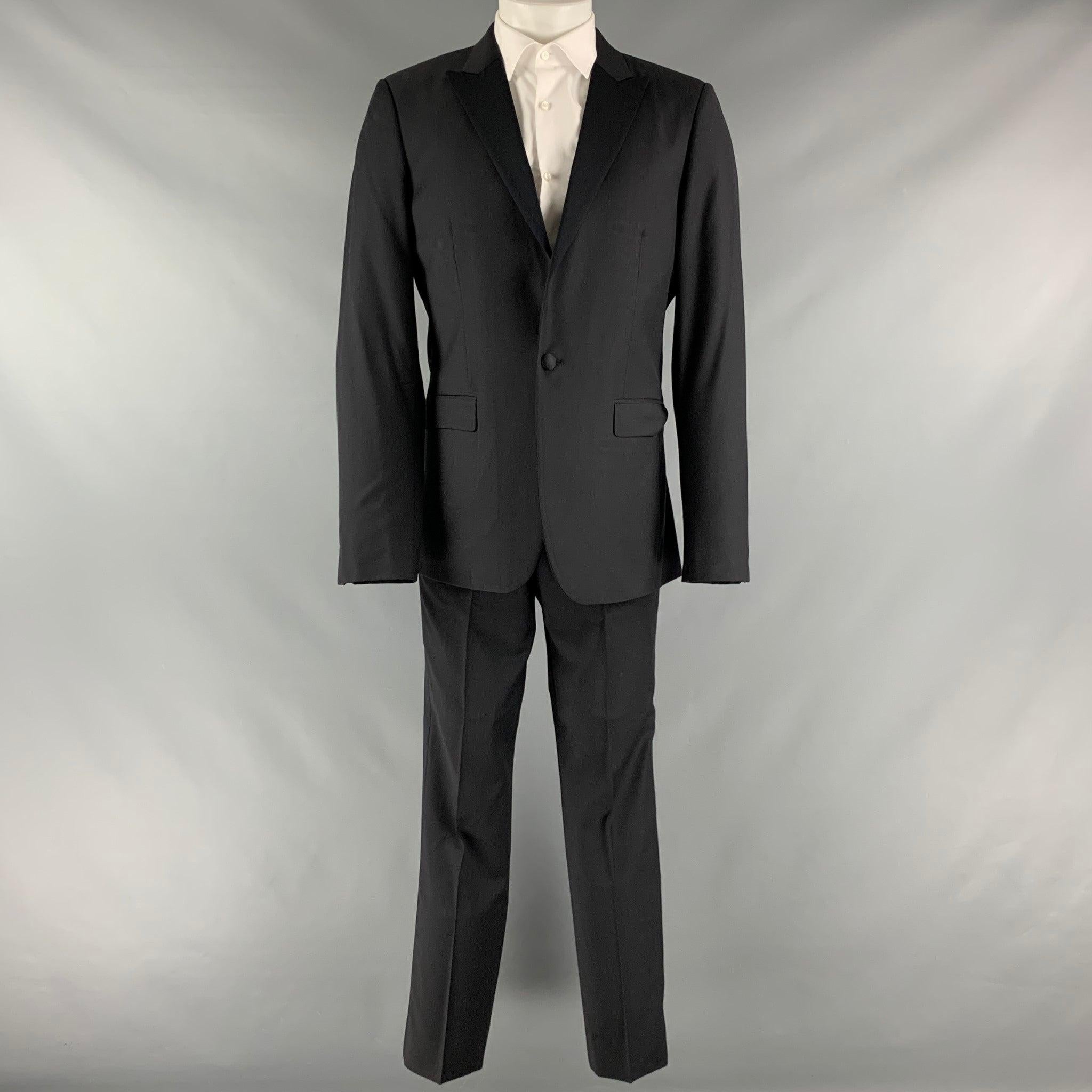 CALVIN KLEIN COLLECTION tuxedo comes in a black wool and includes a single breasted, single button sport coat with a peak lapel and matching flat front trousers. Made in Italy.Very Good Pre-Owned Condition. Minor mark at back. 

Marked:   48